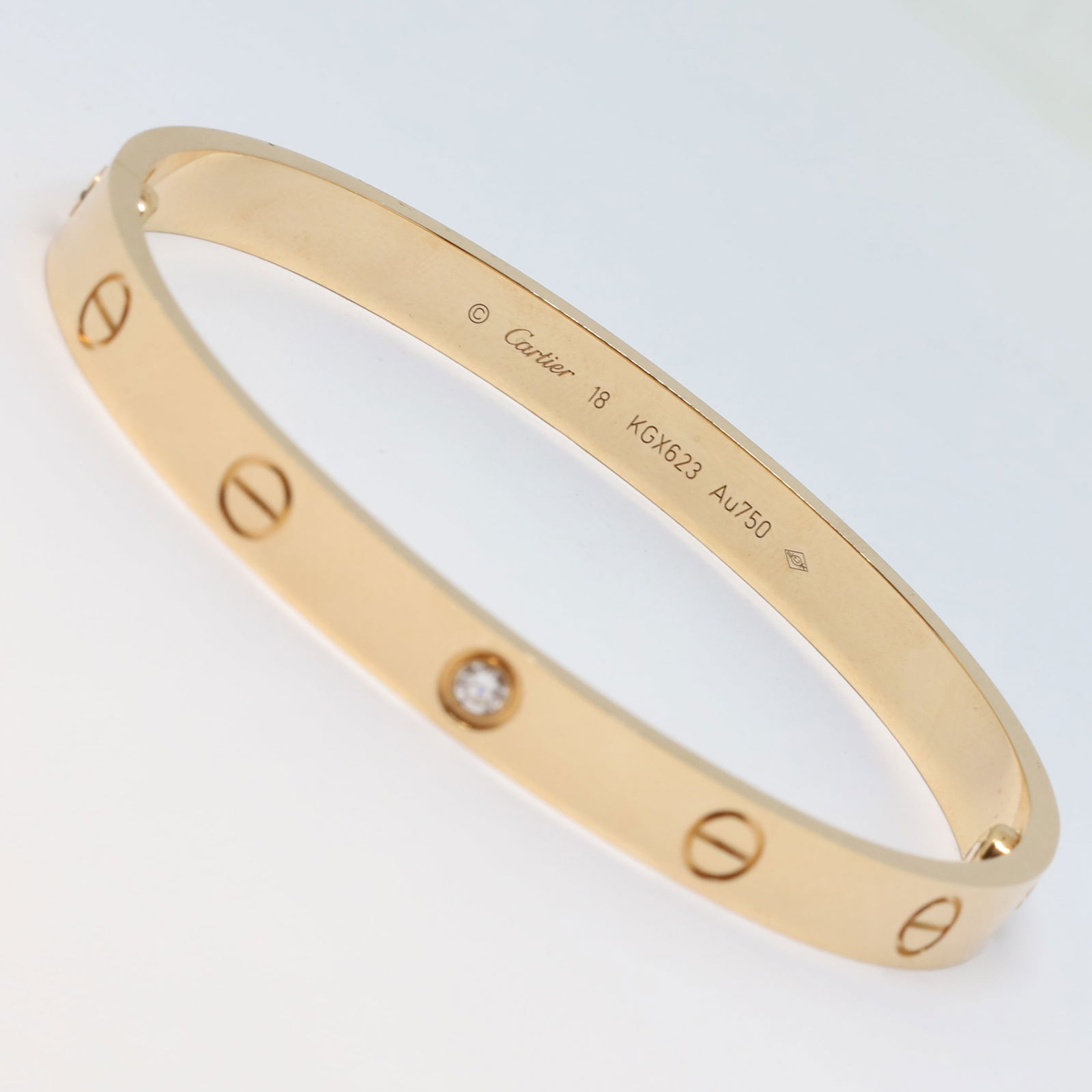 CARTIER DIAMOND LOVE BANGLE: CARTIER DIAMOND LOVE BANGLE,33.9 grams, 18 ct. gold.Rare and unusual Cartier single diamond set love bangle,Diam. 6 mm.Bright and lively diamond.Signed Cartier, Numbered and Cartier makers mark.Size 1
