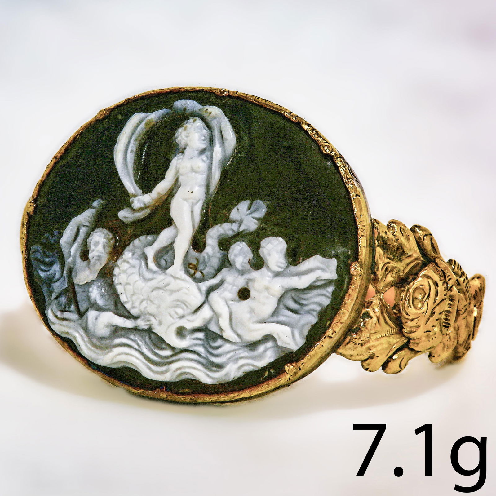 FINE AND RARE GEORGIAN CAMEO RING: FINE AND RARE GEORGIAN CAMEO RING,7.1 grams.The fine cared cameo depicting a cherub on a mythical fish in the sea, surrounded with figures.W. cameo. 2 cm.Size O 1/2.