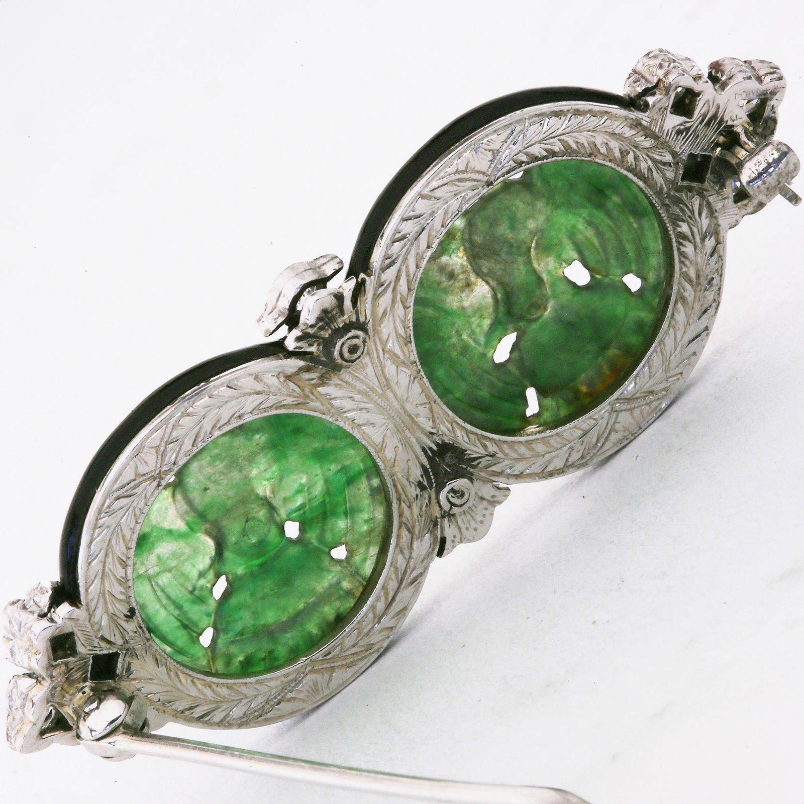 FINE ART-DECO JADE, DIAMOND, RUBY AND ENAMEL BROOCH: FINE ART-DECO JADE, DIAMOND, RUBY AND ENAMEL BROOCH13 grams, testing high carat gold.2 carved jade plaques depicting birds.Diamonds bright and lively.Enamel in good condition.The back finely engraved.