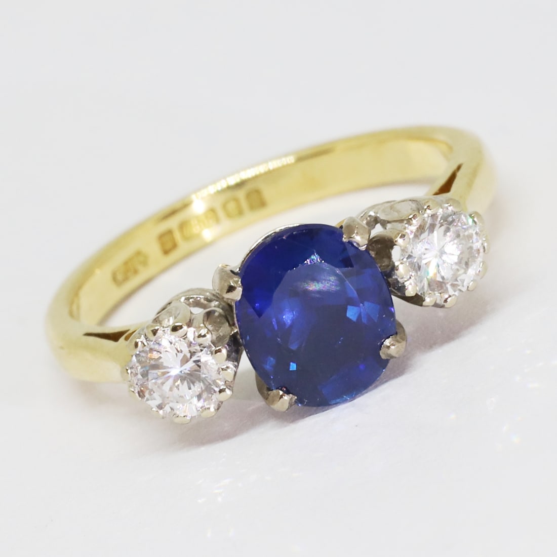 SAPPHIRE AND DIAMOND CLUSTER RING: SAPPHIRE AND DIAMOND CLUSTER RING,3,5 grams, 18 ct. goldRich and vibrant sapphire of approx. 1.52 ct.Diamonds bright and lively.Size L.