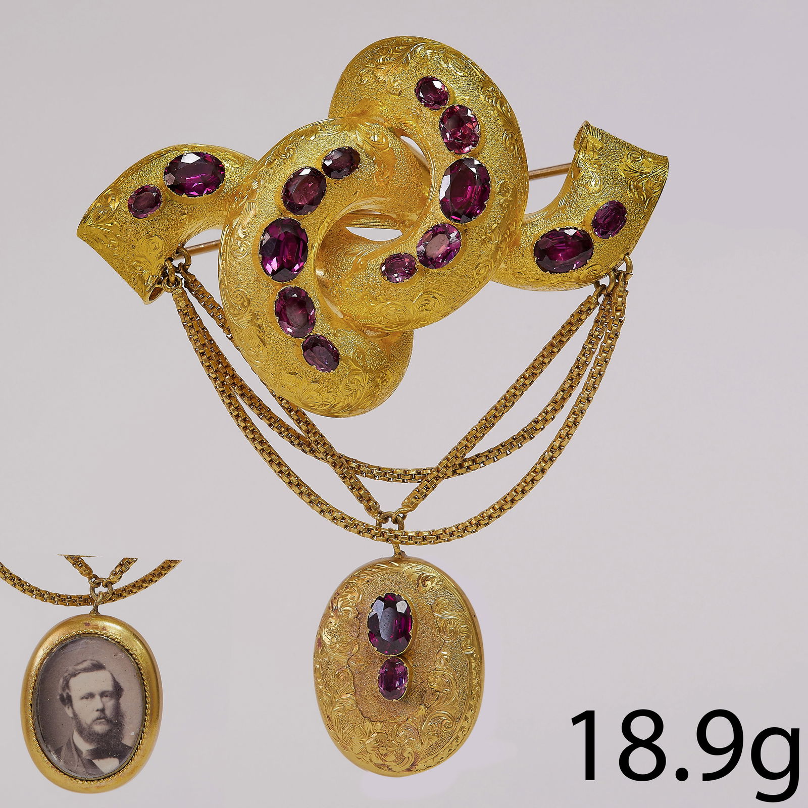 VICTORIAN GARNET BROOCH: VICTORIAN GARNET BROOCH,18.9 grams, testing 15 ct. gold.Vibrant well matched garnets.Fine engraving.The drop with locket back.L. 7.8 cm.