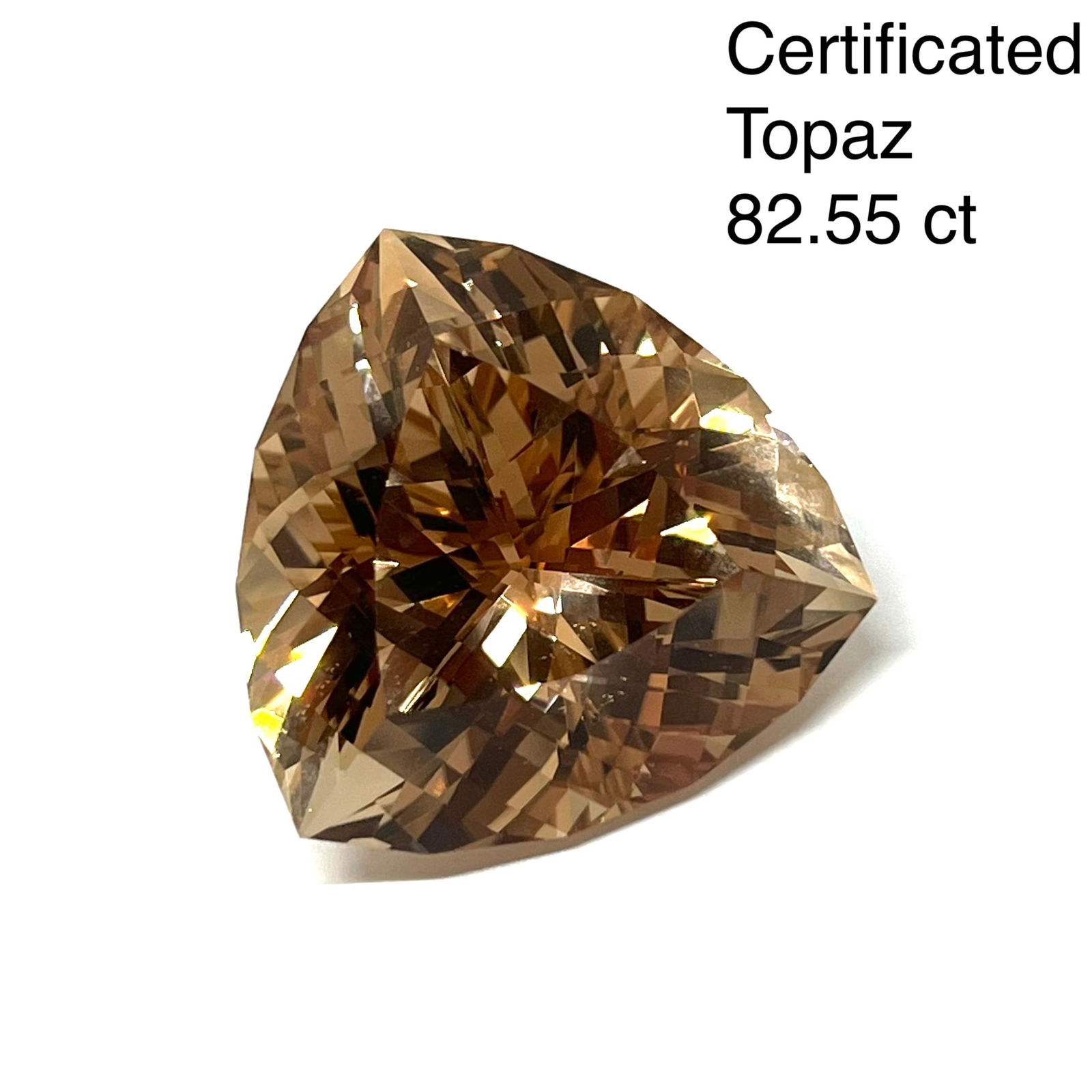 CERTIFICATED LARGE FANCY TOPAZ OF APPROX. 82.55 CT: CERTIFICATED LARGE FANCY TOPAZ OF APPROX. 82.55 CT.The topaz of trilliant mixed cut, of 82.55 ct.27.60 x 27.35 x 17.85 mm.See certificate