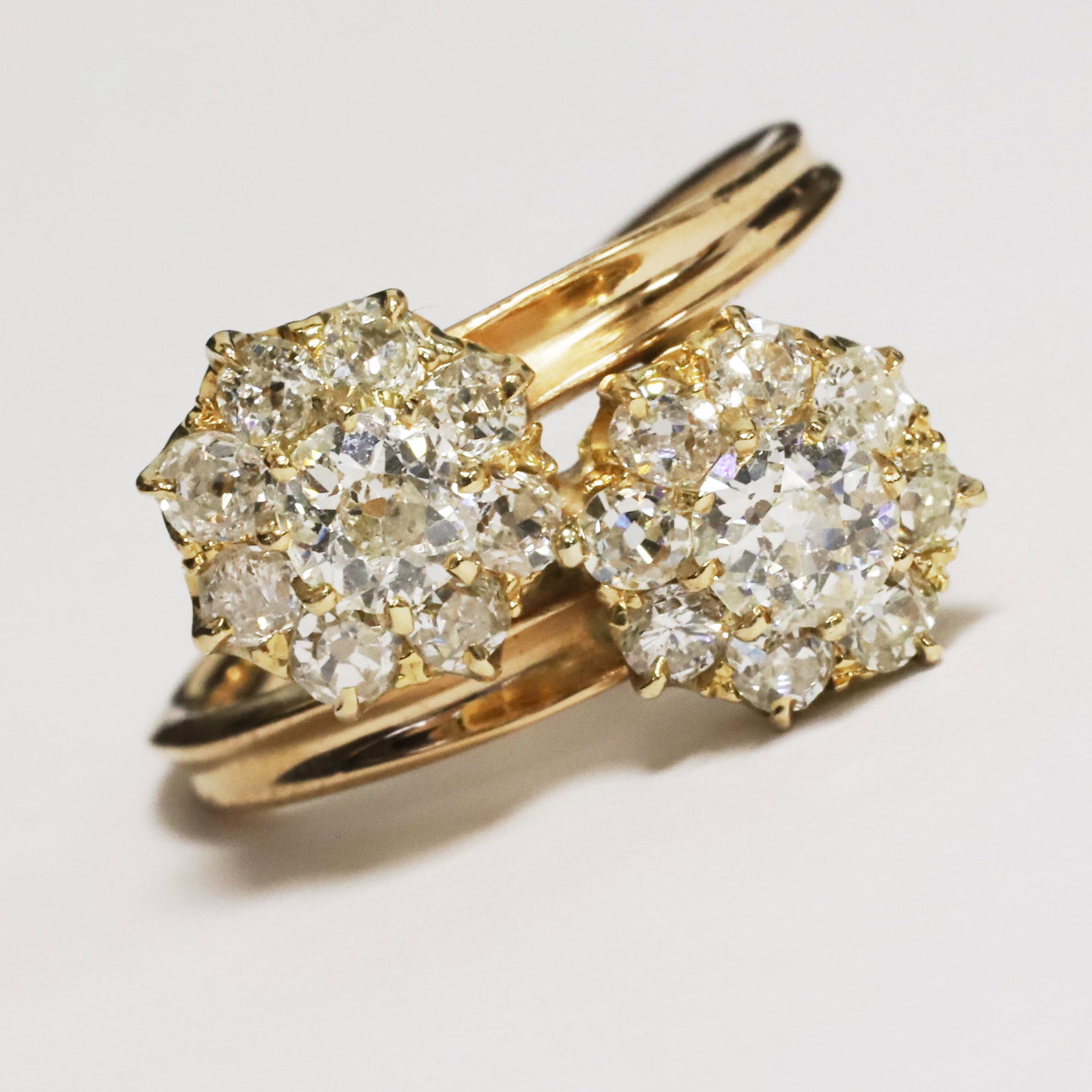 DIAMOND DOUBLE CLUSTER TWIST RING: DIAMOND DOUBLE CLUSTER TWIST RING,testing high carat gold.Bright and lively old cut diamonds, totalling approx. 0.96 ct.Size J.