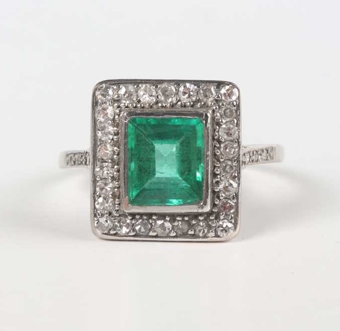 EMERALD AND DIAMOND CLUSTER RING: EMERALD AND DIAMOND CLUSTER RING,3,8 grams, 18 ct. gold and platinum.Rich and vibrant emerald of approx. 1.71 ct., likely Colombian.Diamonds bright and lively.Size L.