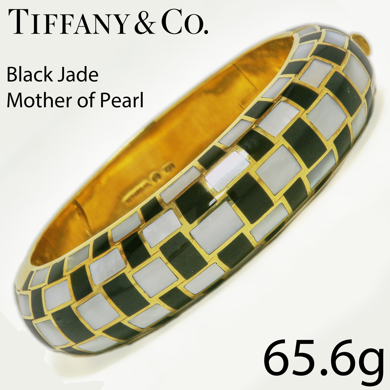 ANGELA CUMMINGS FOR TIFFANY & CO., MOTHER OF PEARL AND BLACK JADE BANGLE: ANGELA CUMMINGS FOR TIFFANY & CO., MOTHER OF PEARL AND BLACK JADE BANGLE,65.6 grams, 18 ct. gold.The bangle all around fine inlaid with 'checkerboard' pattern, consisting of mother of pearl and black