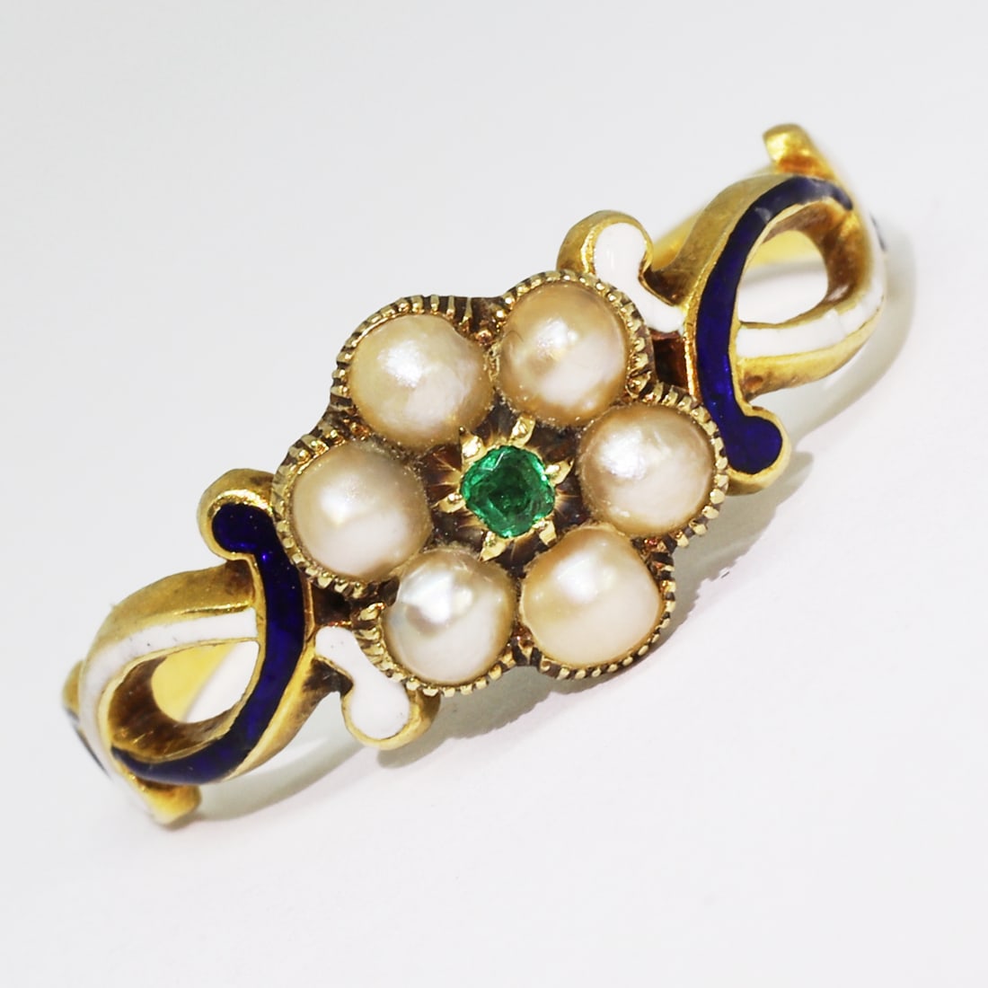 SWEET VICTORIAN ENAMEL PEARL AND EMERALD RING: SWEET VICTORIAN ENAMEL PEARL AND EMERALD RING,testing high carat gold.Lovely emerald.Pearls generally well matched.The shoulders with lovely white and blue enamel.Locket back.Size L.