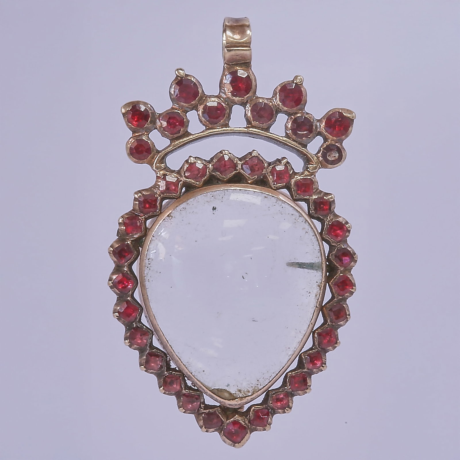 GEORGIAN GARNET AND ROCK CRYSTAL LOCKET PENDANT: GEORGIAN GARNET AND ROCK CRYSTAL LOCKET PENDANT3.6 grams, testing gold. With an opening compartment to hold a picture. L. 3 cm.