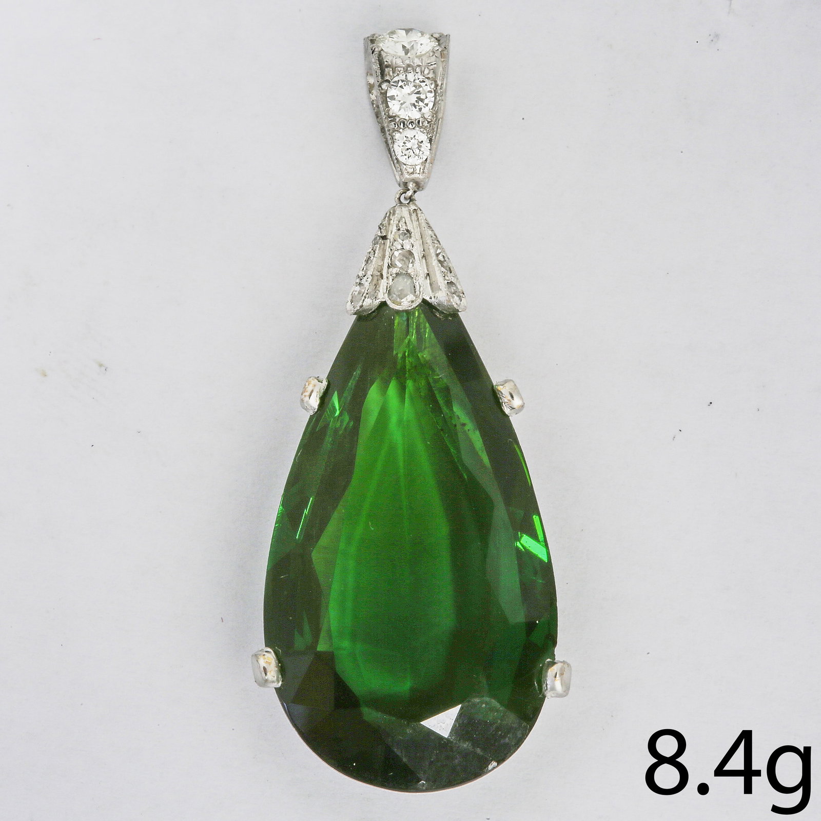 FINE TOURMALINE AND DIAMOND PENDANT: FINE TOURMALINE AND DIAMOND PENDANT,8..3 grams, testing high carat gold.Large pear shaped green tourmaline, of approx. 22.65 ct.Diamonds bright and lively.L. 4.6 cm.