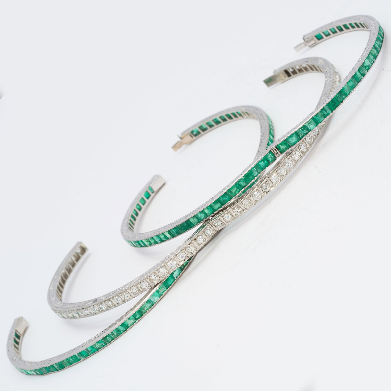 EXQUISITE SET OF 3 ART-DECO EMERALD AND DIAMOND HINGED BRACELETS: EXQUISITE SET OF 3 ART-DECO EMERALD AND DIAMOND HINGED BRACELETS50 grams, platinum.2 bangles fully set with emeralds, totalling approx. 11 ct.1 bangle fully set with diamonds, totalling approx. 4.75 c