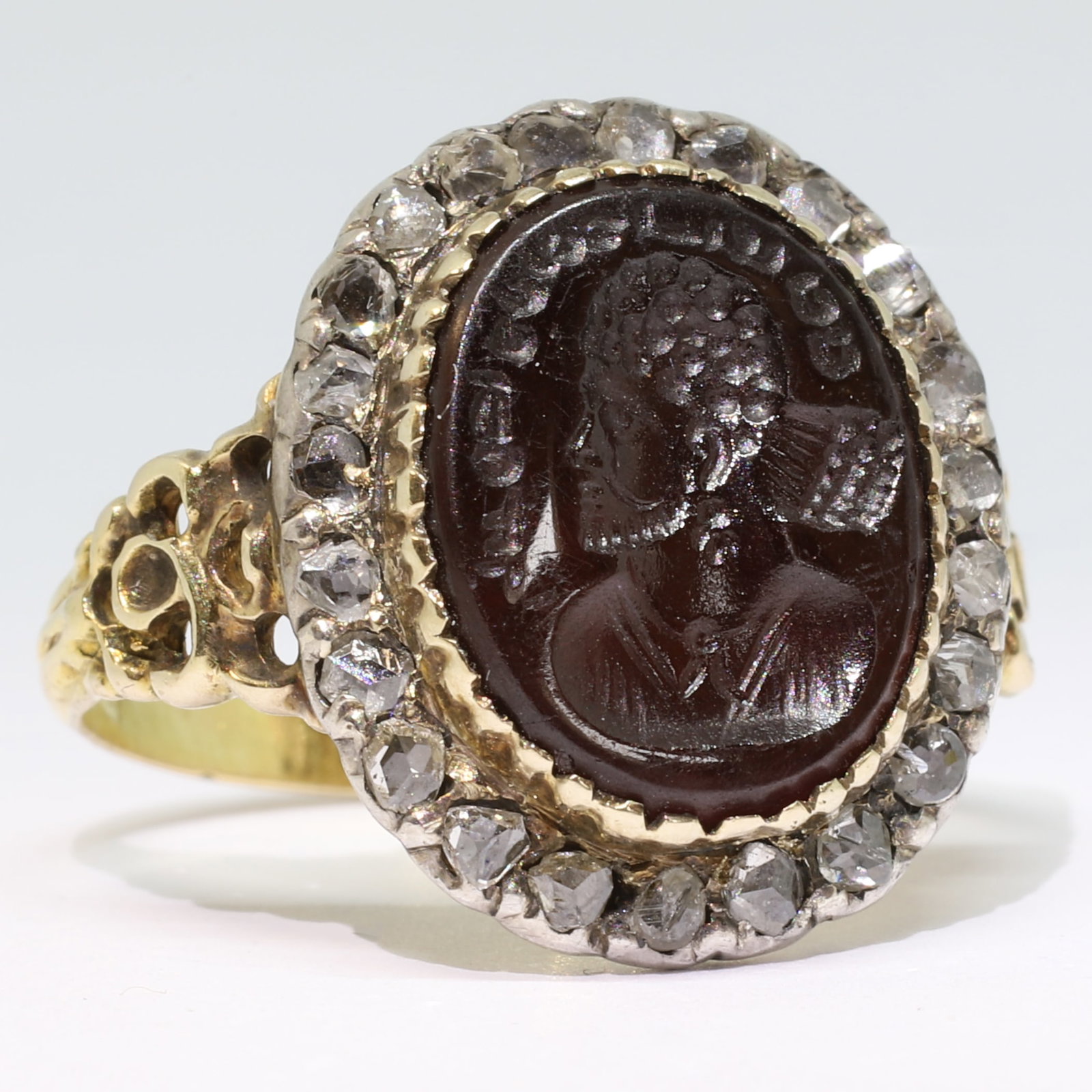 ANTIQUE INTAGLIO DIAMOND CLUSTER RING: ANTIQUE INTAGLIO DIAMOND CLUSTER RING,5,5 grams, testing high carat gold and silver.The carved intaglio depicting a man in profile with text.The surmount with diamonds.Size L 1/2.