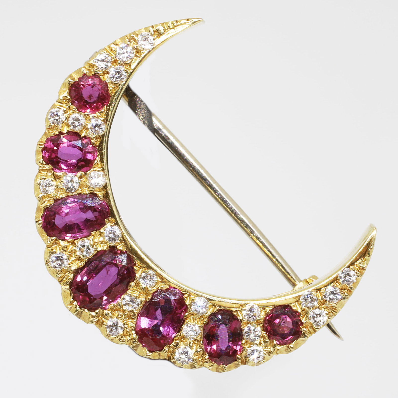 RUBY AND DIAMOND CRESCENT BROOCH: RUBY AND DIAMOND CRESCENT BROOCH,6.6 grams, 18 ct. gold.Rich and vibrant rubies, totalling approx. 2.80 ct.Diamonds bright and lively.Diam. 2.7 cm.