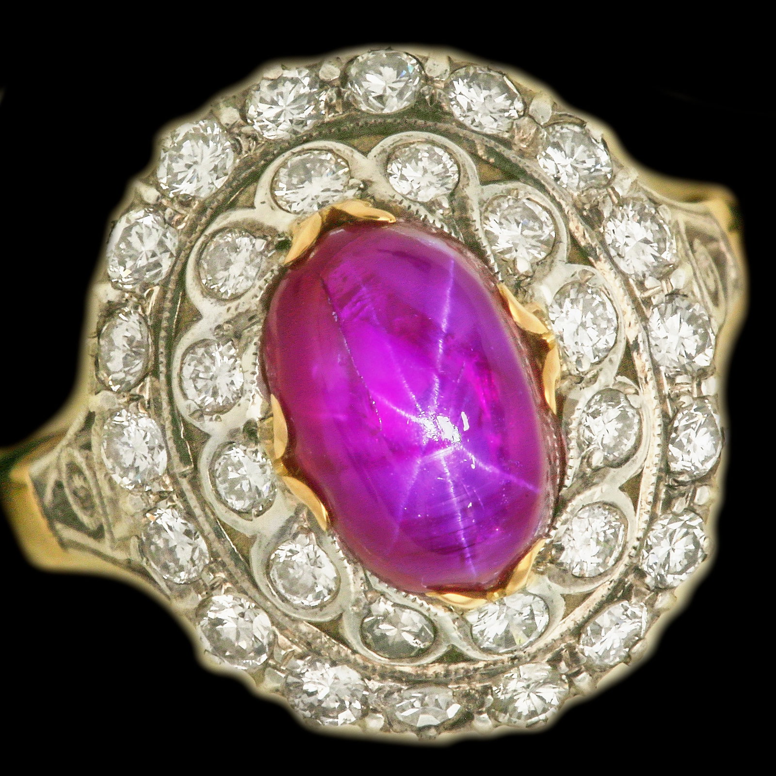 RUBY AND DIAMOND CLUSTER RING: RUBY AND DIAMOND CLUSTER RING,5,2 grams, 14 ct. gold and silver.Vibrant cabochon cut ruby of approx. 4 ct.Diamonds bright and lively.Size N.