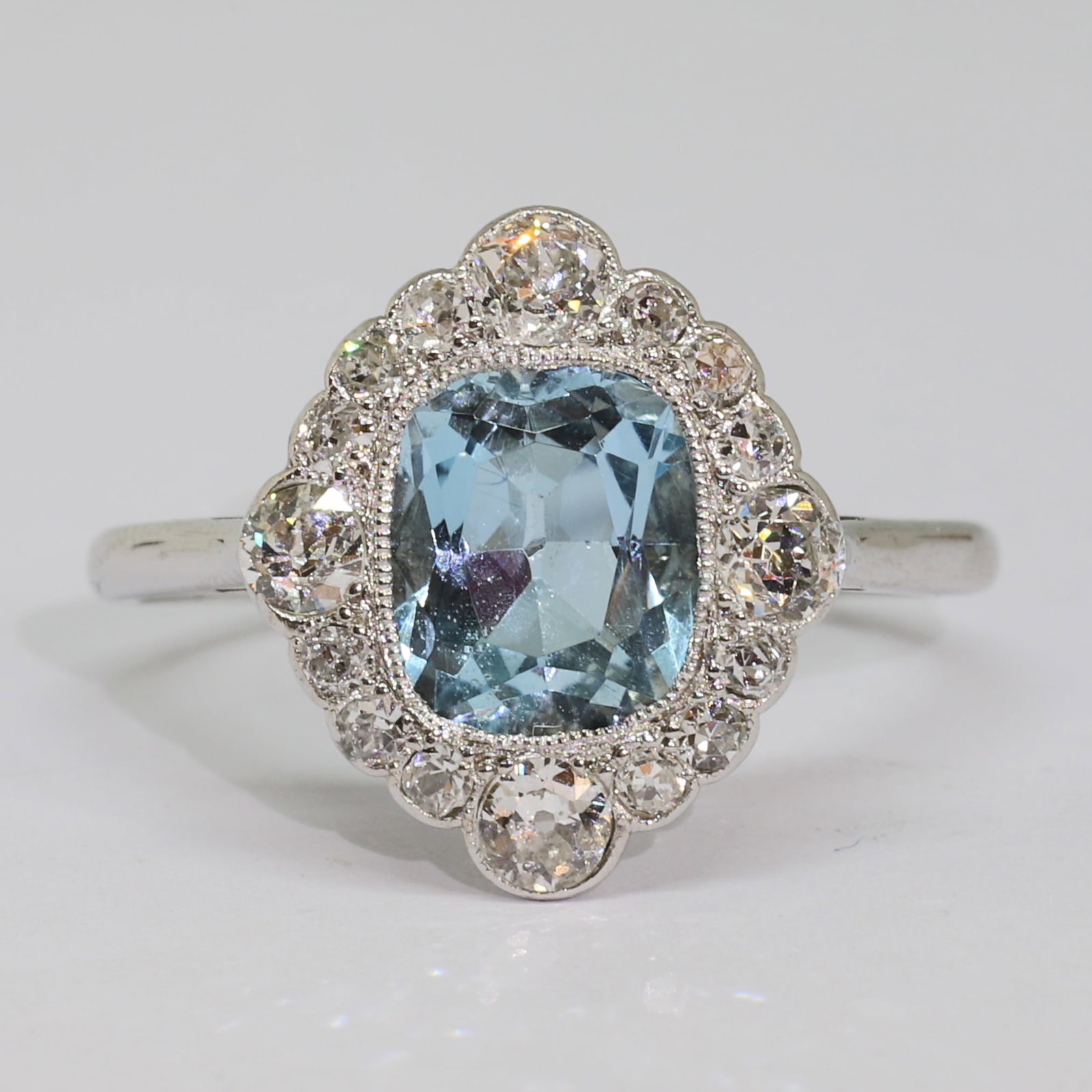 EDWARDIAN AQUAMARINE AND DIAMOND CLUSTER RING: EDWARDIAN AQUAMARINE AND DIAMOND CLUSTER RING,3 grams, 18 ct. gold and platinum.Rich and vibrant aquamarine of approx. 1.45 ct.Diamonds bright and lively.Size N 1/2.