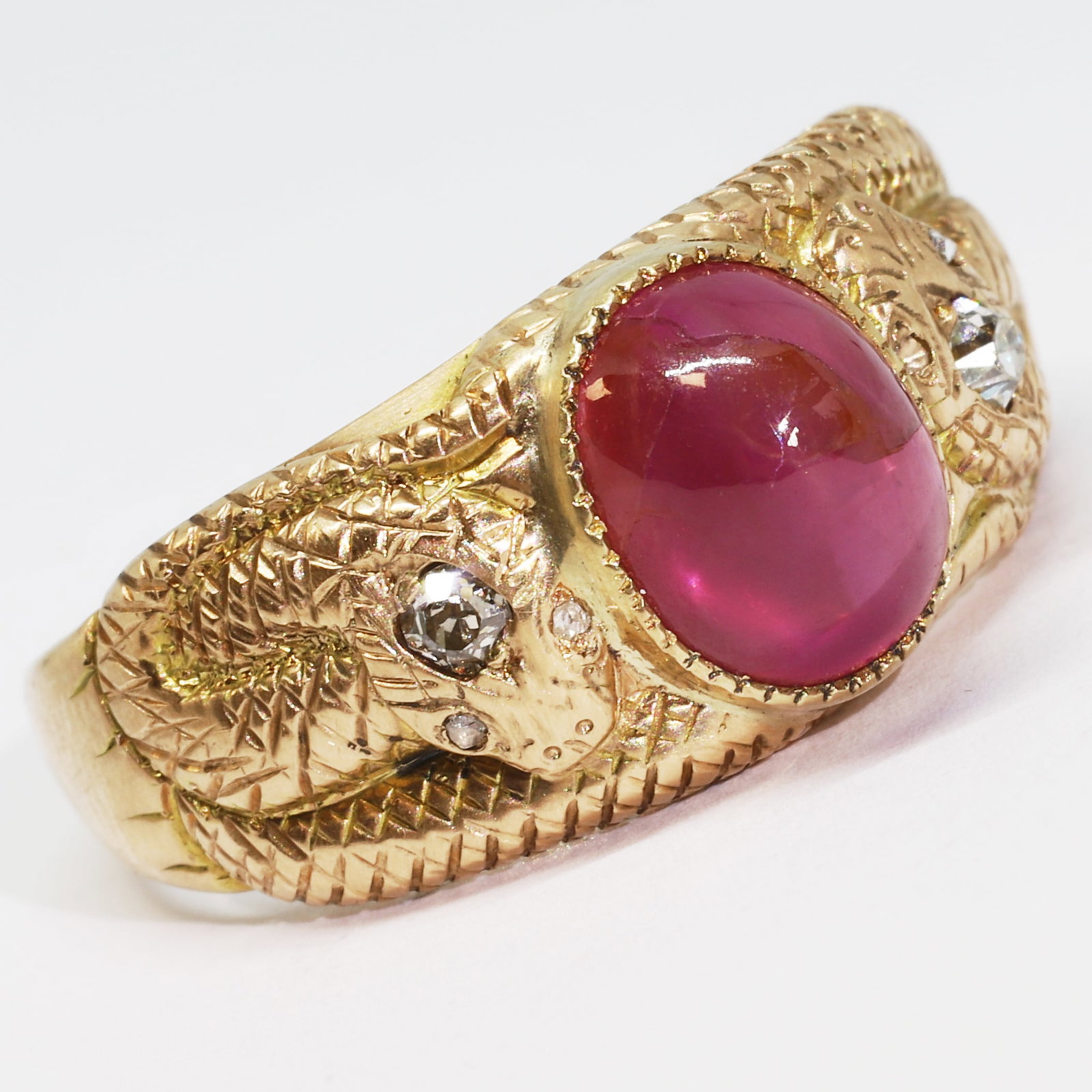 FINE RUBY AND DIAMOND DOUBLE SNAKE RING: FINE RUBY AND DIAMOND DOUBLE SNAKE RING,9 grams, testing high carat gold.FIne cabochon cut ruby of approx. 4.45 ct.Diamonds bright and lively.Size R 1/2.