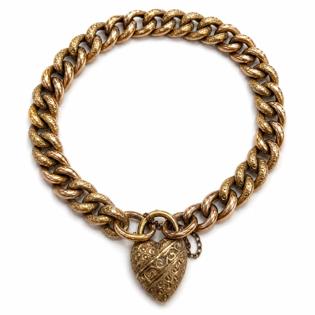 ANTIQUE CURB LINK GOLD BRACELET: ANTIQUE CURB LINK GOLD BRACELET,14,2 grams.The bracelet with part textured design links.Lovely relief design heart clasp.L. 19 cm.