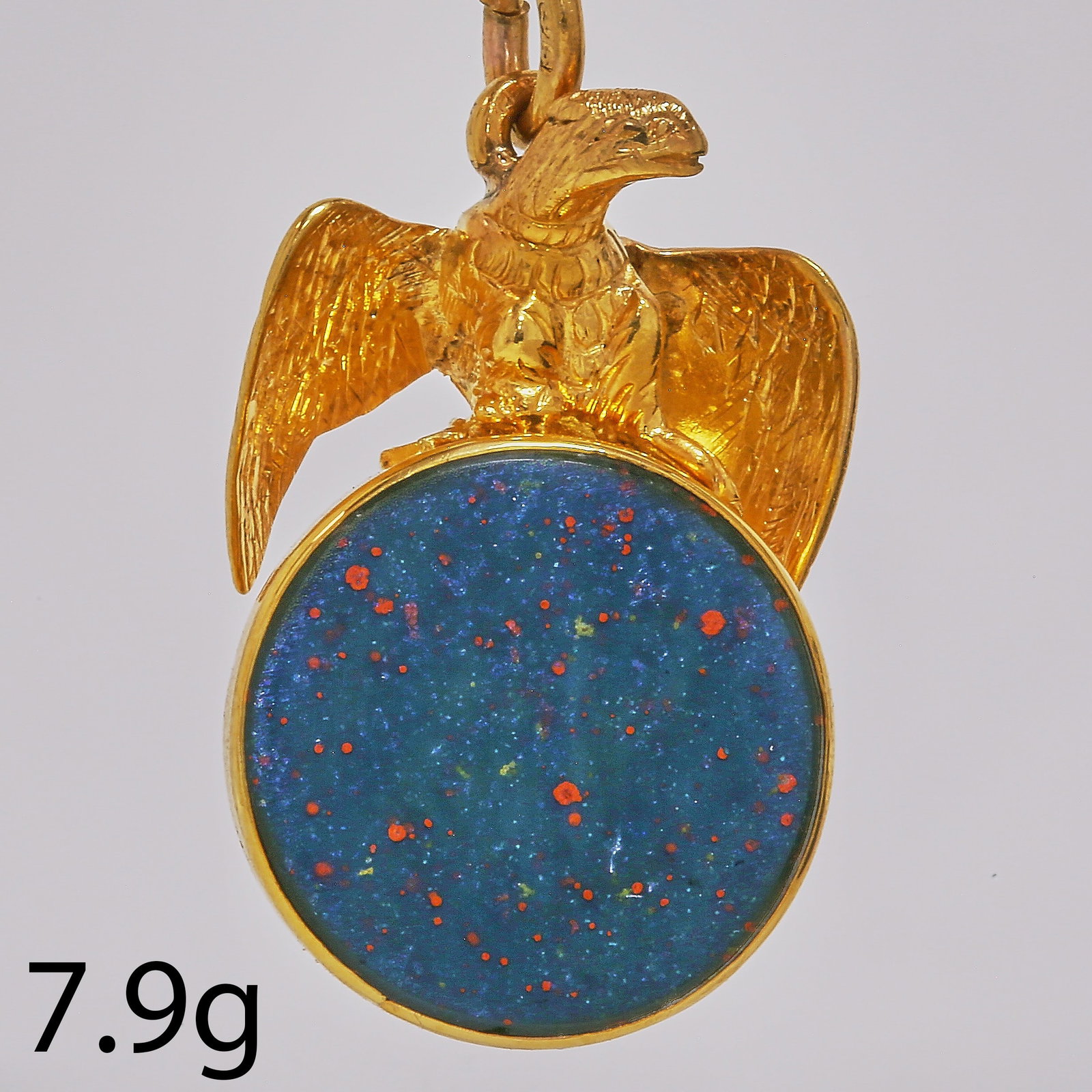 GOLD EAGLE BLOODSTONE FOB SEAL PENDANT: GOLD EAGLE BLOODSTONE FOB SEAL PENDANT,7.9 grams.The 3 dimensional shaped eagle holding a tilting bloodstone in his claws.L. 3.2 cm.