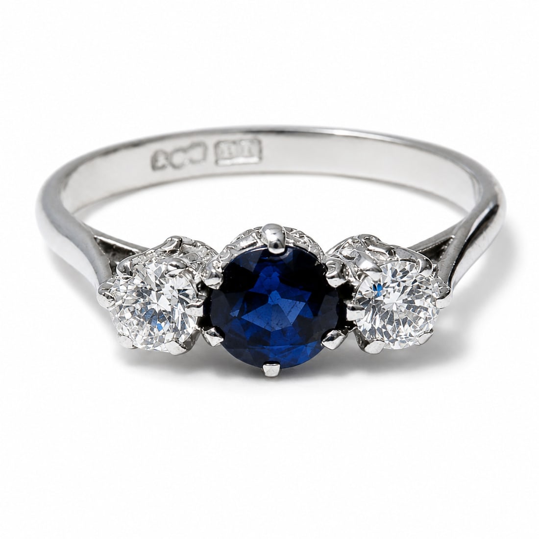 SAPPHIRE AND DIAMOND 3-STONE RING: SAPPHIRE AND DIAMOND 3-STONE RING,3.6 grams, testing Platinum.With and vibrant sapphire of approx. 0.75 ct.Diamonds bright and lively, totalling approx. 0.50 ct.Size O 1/2.