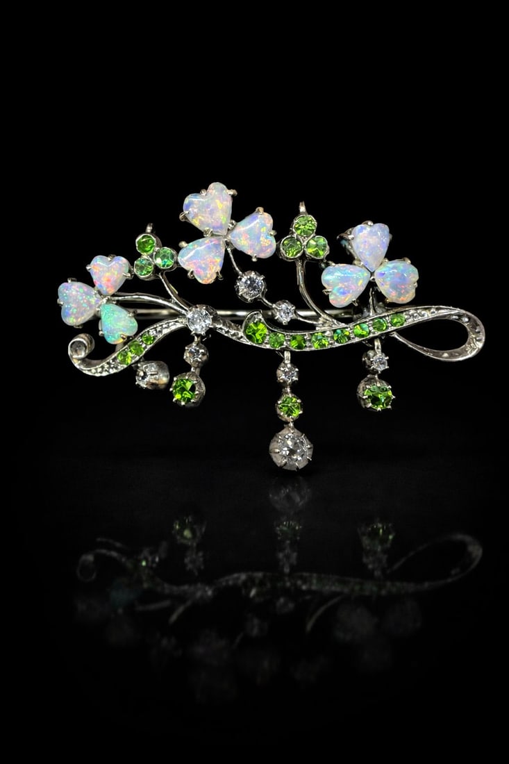 SWEET EDWARDIAN DEMANTOID GARNET, DIAMOND AND OPAL NATURALISTIC BROOCH: SWEET EDWARDIAN DEMANTOID GARNET, DIAMOND AND OPAL NATURALISTIC BROOCH,6,2 grams.Opal with good play of colour including red.Vibrant demantoid garnets.Diamonds bright and lively.W. 4.2 cm.