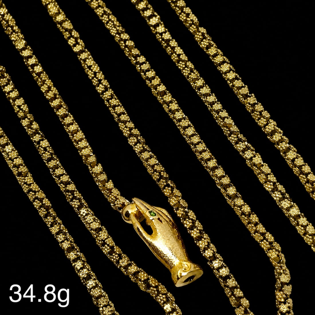 FINE ANTIQUE TRICHINOPOLY CHAIN NECKLACE WITH HAND CLASP: FINE ANTIQUE TRICHINOPOLY CHAIN NECKLACE WITH HAND CLASP,34.8 grams, testing high carat gold.Fine intricate 'trichinopoly' link.The hand clasp set with an emerald.L. 107 cm.
