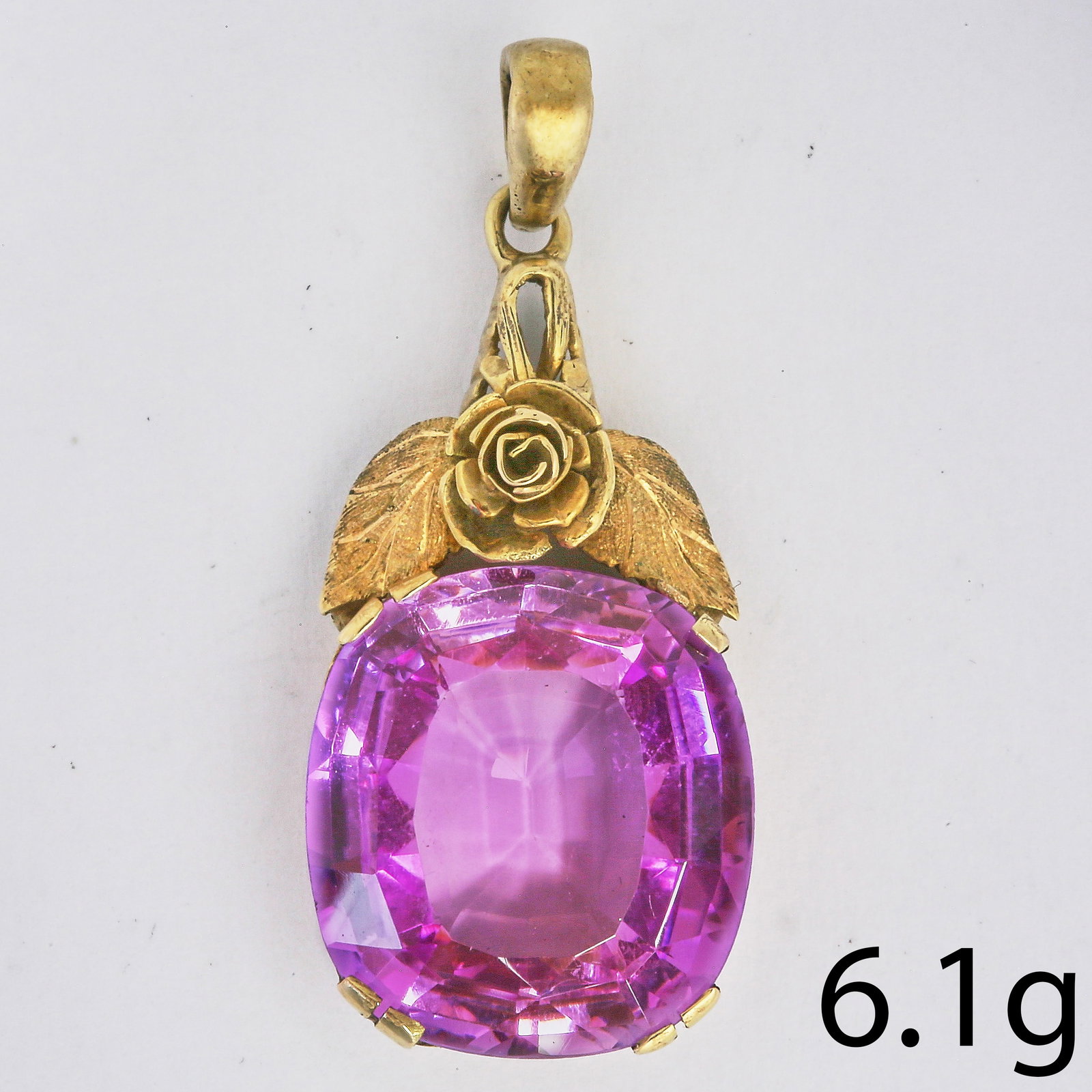 PINK SAPPHIRE PENDANT: PINK SAPPHIRE PENDANT,6.1 grams, testing high carat gold.Vibrant pink sapphire of approx. 16.7 x 15.1 x 7.1 mm. Pink sapphire presumed to be synthetic.L. 3.6 cm.