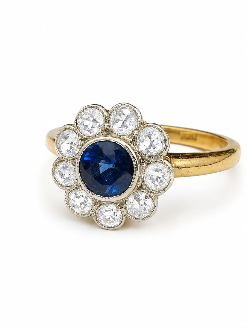 SAPPHIRE AND DIAMOND CLUSTER RING: SAPPHIRE AND DIAMOND CLUSTER RING,18 ct. gold.Rich and vibrant sapphire of approx. 0.85 ct.Bright and lively old cut diamonds totalling approx. 0.75 ct.Size P.