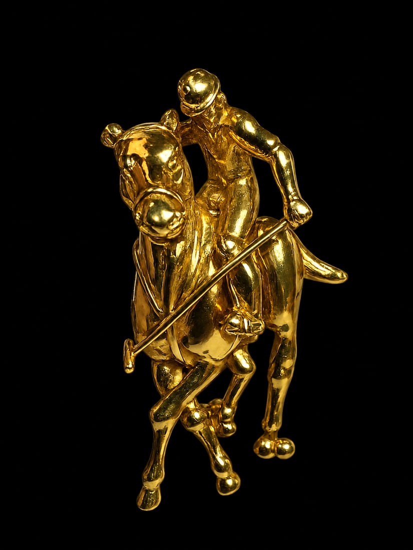 THEO FENNELL, POLO PLAYER AND HORSE BROOCH: THEO FENNELL, POLO PLAYER AND HORSE BROOCH,19.5 grams, 18 ct. gold.Depicting a polo player on a horse.Signed Fennell.L. 4.6 cm.With pouch and box.
