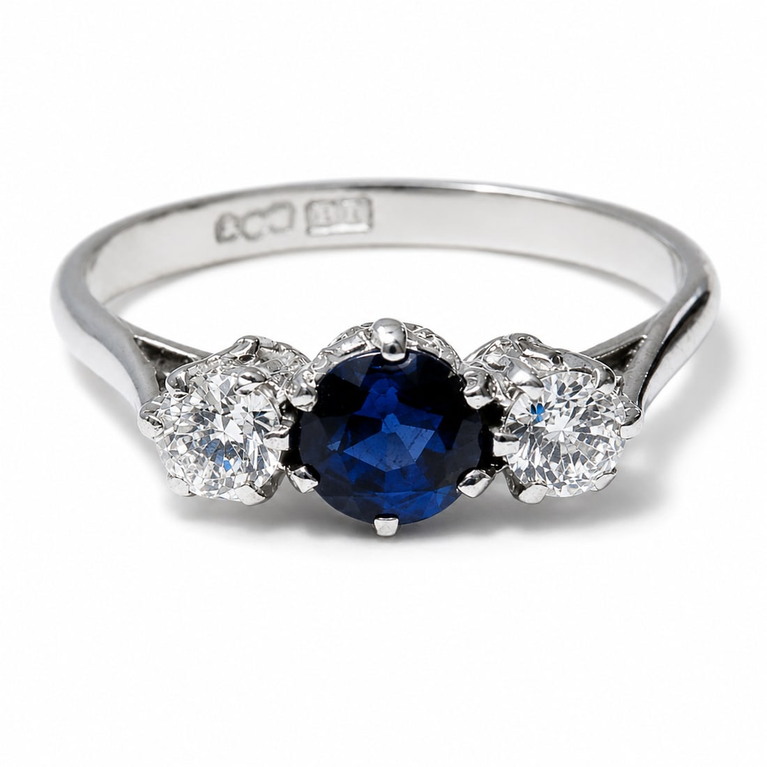 SAPPHIRE AND DIAMOND 3-STONE RING: SAPPHIRE AND DIAMOND 3-STONE RING,3.6 grams, testing Platinum.With and vibrant sapphire of approx. 0.75 ct.Diamonds bright and lively, totalling approx. 0.50 ct.Size O 1/2.