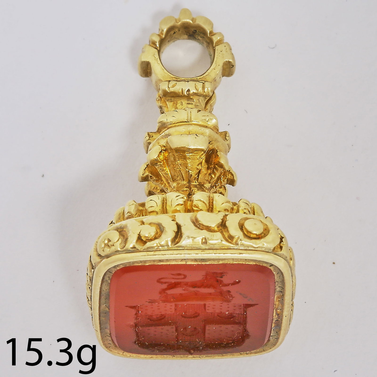 ANTIQUE CARVED INTAGLIO FOB SEAL: ANTIQUE CARVED INTAGLIO FOB SEAL,15,5 grams, testing high carat gold.The carved intaglio hardstone depicting a coat of arms, topped with a lion and crown.L. 2.9 cm.