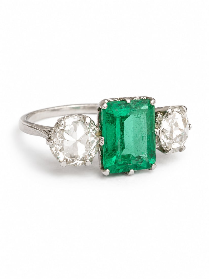 COLOMBIAN EMERALD AND DIAMOND THREE STONE RING: COLOMBIAN EMERALD AND DIAMOND THREE STONE RING 3.7 grams, testing 18 ct. gold.Rich and vibrant emerald of approx. 1.90 ct.Diamonds bright and lively, totalling approx. 1.60 ct.Size N 1/2.