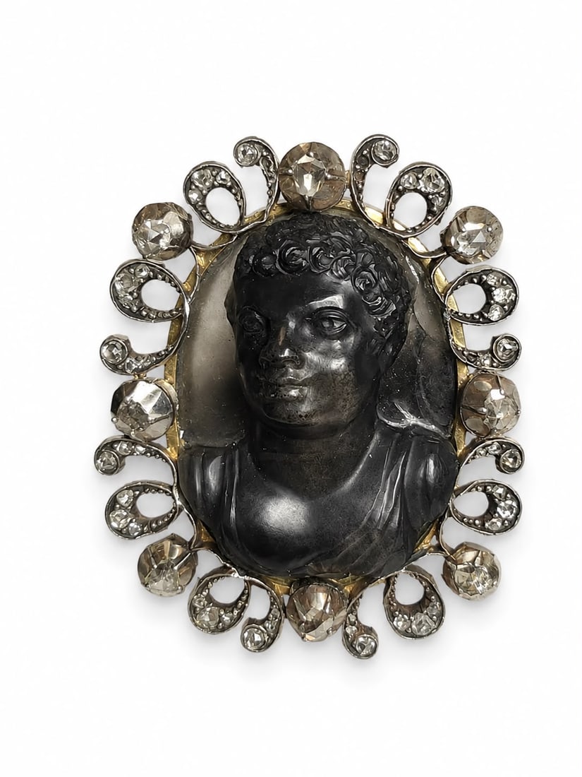 RARE ANTIQUE HARDSTONE CAMEO BROOCH: RARE ANTIQUE HARDSTONE CAMEO BROOCH,15.1 grams.The fine carved agate cameo depicting a blackamoor.The surmount set with diamonds.L. 4 cm.