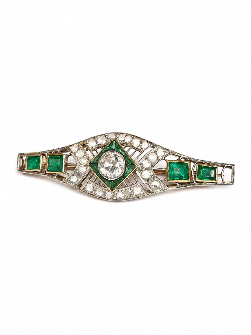 EDWARDIAN EMERALD AND DIAMOND BROOCH: EDWARDIAN EMERALD AND DIAMOND BROOCH,5,2 grams, testing gold and platinum.Bright and lively diamonds, totalling approx. 1.90 ct.Rich and vibrant emeralds.W. 4.9 cm.