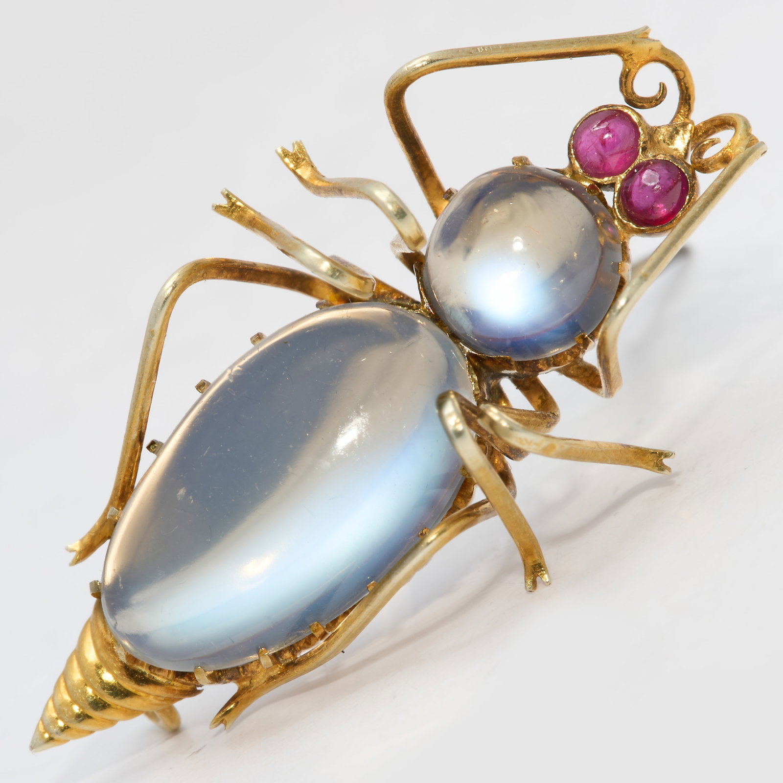 MOONSTONE AND RUBY BUG BROOCH: MOONSTONE AND RUBY BUG BROOCH,testing 15 ct. gold.Lovely moonstones with nice blue shiller.L. 3 cm.