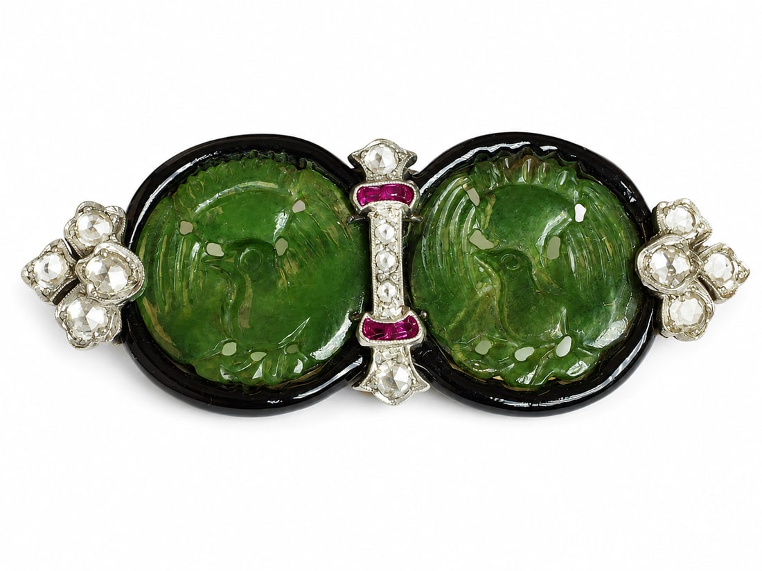 FINE ART-DECO JADE, DIAMOND, RUBY AND ENAMEL BROOCH: FINE ART-DECO JADE, DIAMOND, RUBY AND ENAMEL BROOCH13 grams, testing high carat gold.2 carved jade plaques depicting birds.Diamonds bright and lively.Enamel in good condition.The back finely engraved.