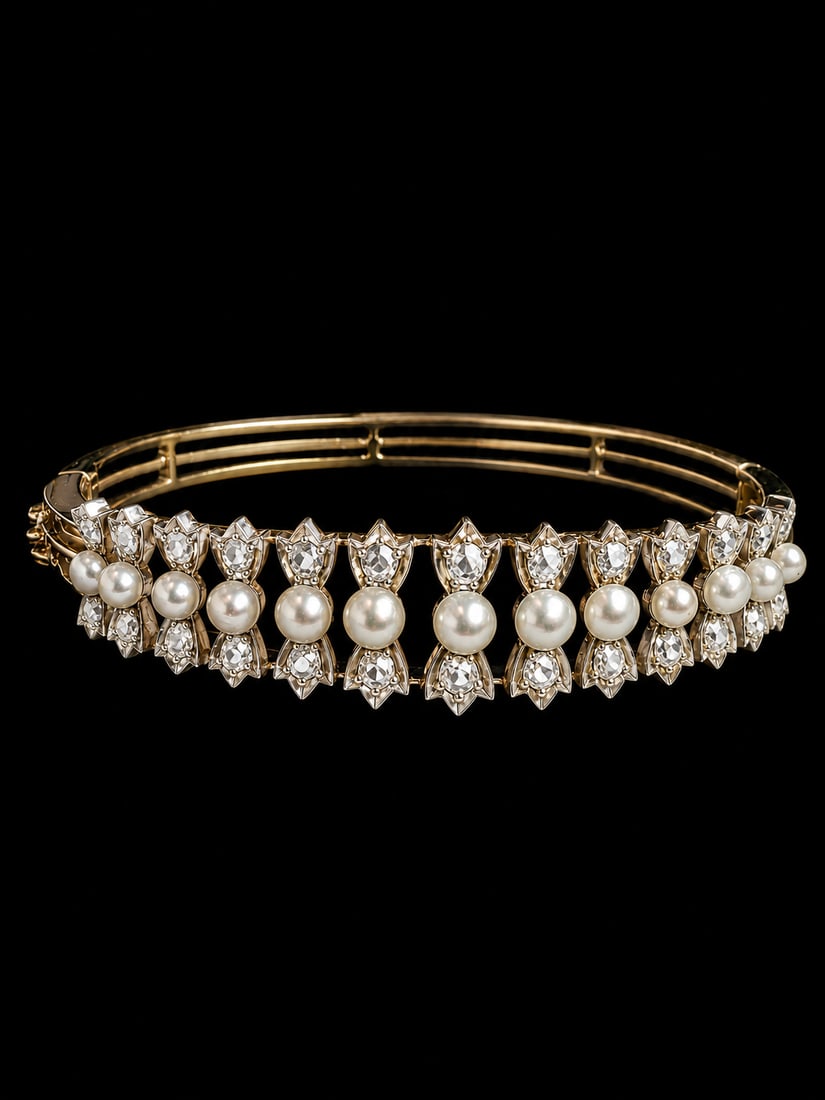 FRENCH PEARL AND DIAMOND HINGED BANGLE: FRENCH PEARL AND DIAMOND HINGED BANGLE,18.5 grams, testing 18 ct. gold.Lovely pearls, graduated in size (untested, believed to be natural).Diamonds bright and lively.Inner diam. 5.3 cm.