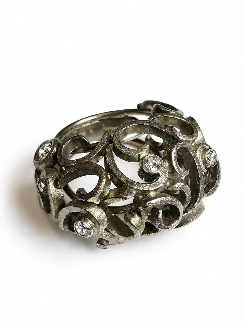 ANDREW GRIMA, DIAMOND RING: ANDREW GRIMA, DIAMOND RING,20.7 grams, 18 ct. gold.The bombe ring of openwork scrolling design, accentuated with bright and lively diamonds.Signed Grima.Size L.