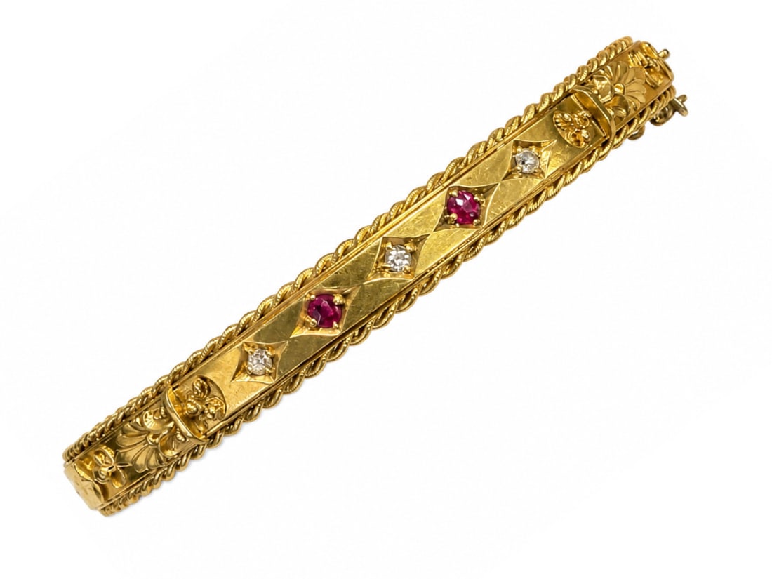 ANTIQUE RUBY AND DIAMOND HINGED BANGLE: ANTIQUE RUBY AND DIAMOND HINGED BANGLE,10.3 grams, 15 ct. gold.Rich and vibrant rubies.Diamonds bright and lively.Inner diam. 5.8 cm.