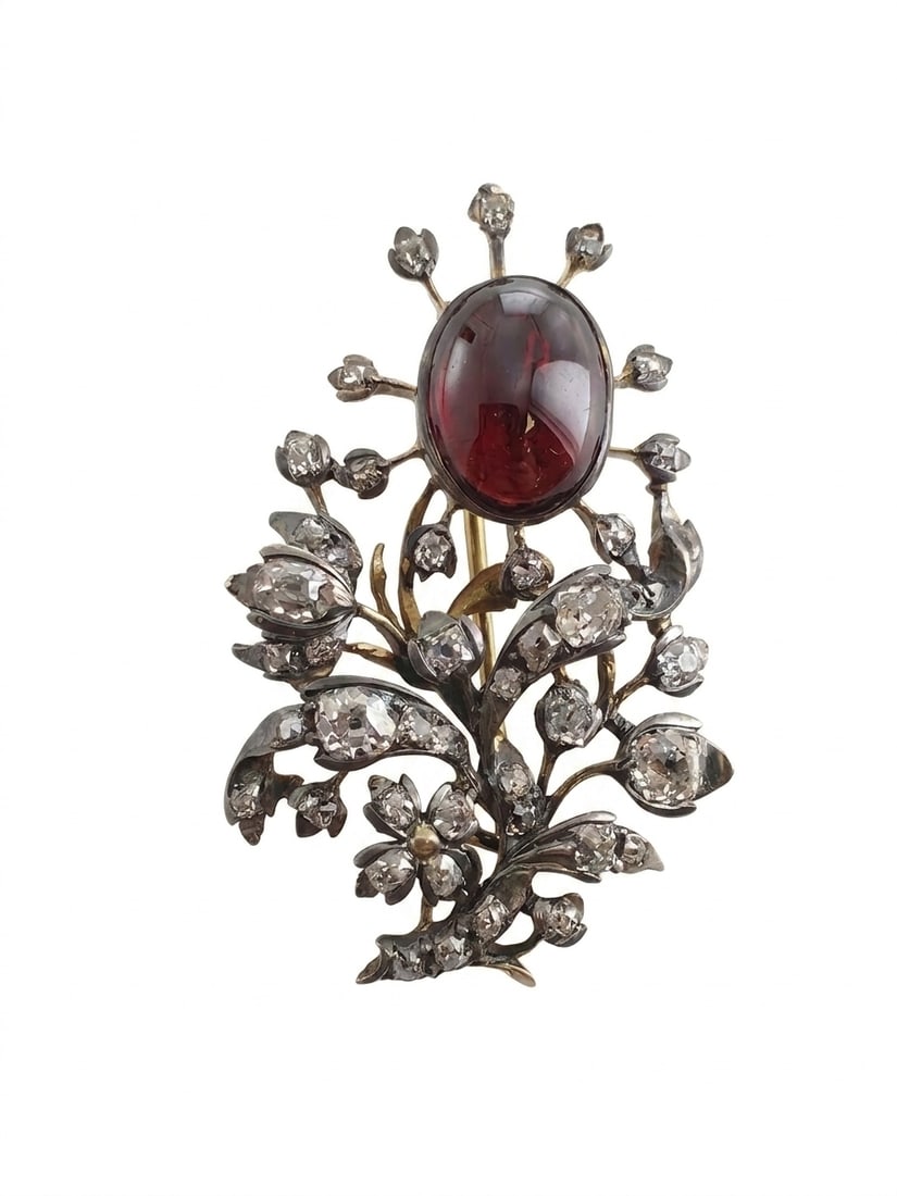 ANTIQUE GARNET AND DIAMOND FLORAL BROOCH: ANTIQUE GARNET AND DIAMOND FLORAL BROOCH,7,3 grams, Testing 18 ct. gold and silver.Bright and lively diamonds, totalling approx. 1.50 ct.Lovely cabochon cut garnet.L. 4 cm.