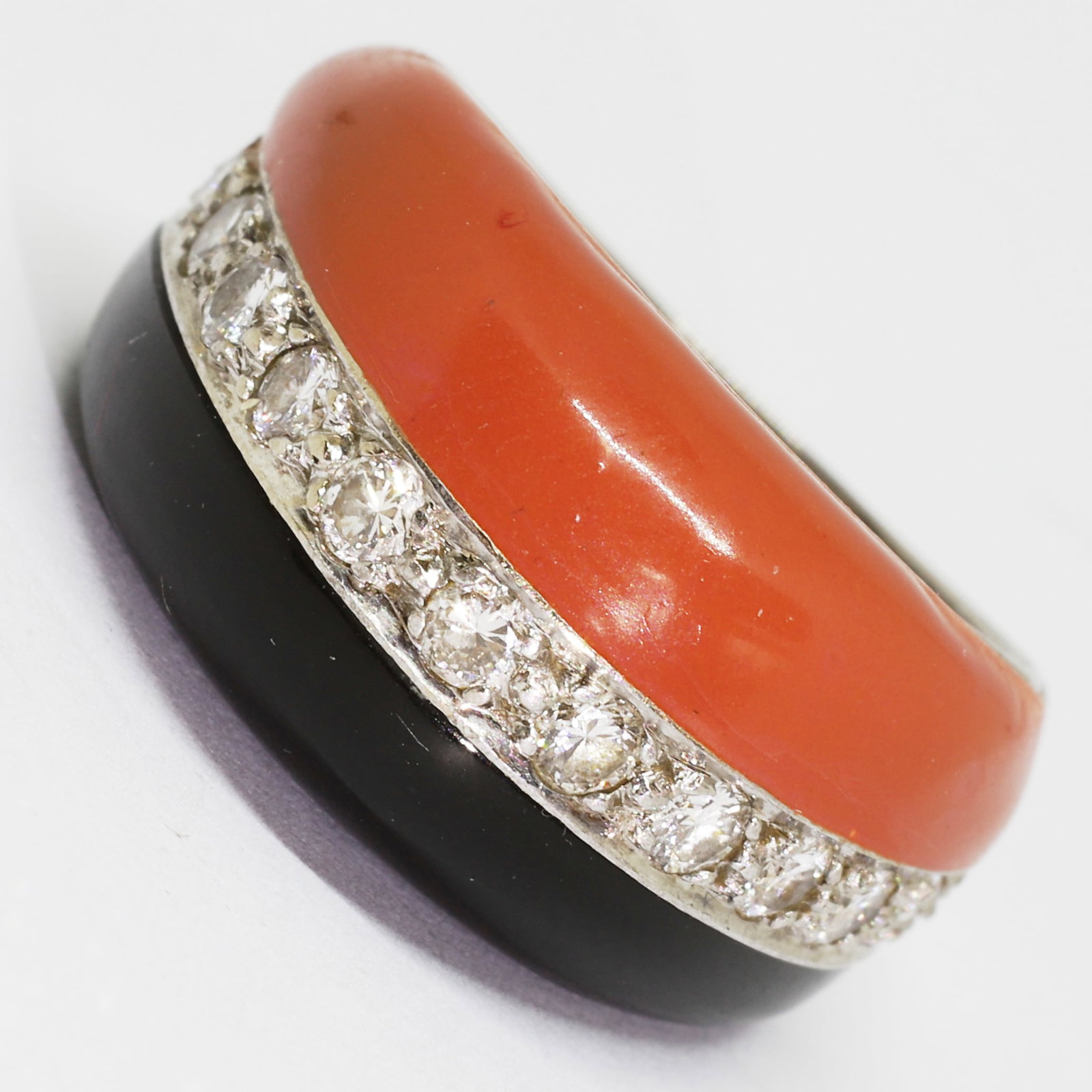 RETRO CORAL ONYX AND DIAMOND BOMBE RING: RETRO CORAL ONYX AND DIAMOND BOMBE RING,9.3 grams, testing 14 ct. gold.Diamonds bright and lively,Flanked with 1 side of fine coral.The other side with onyx.Size L 1/2.