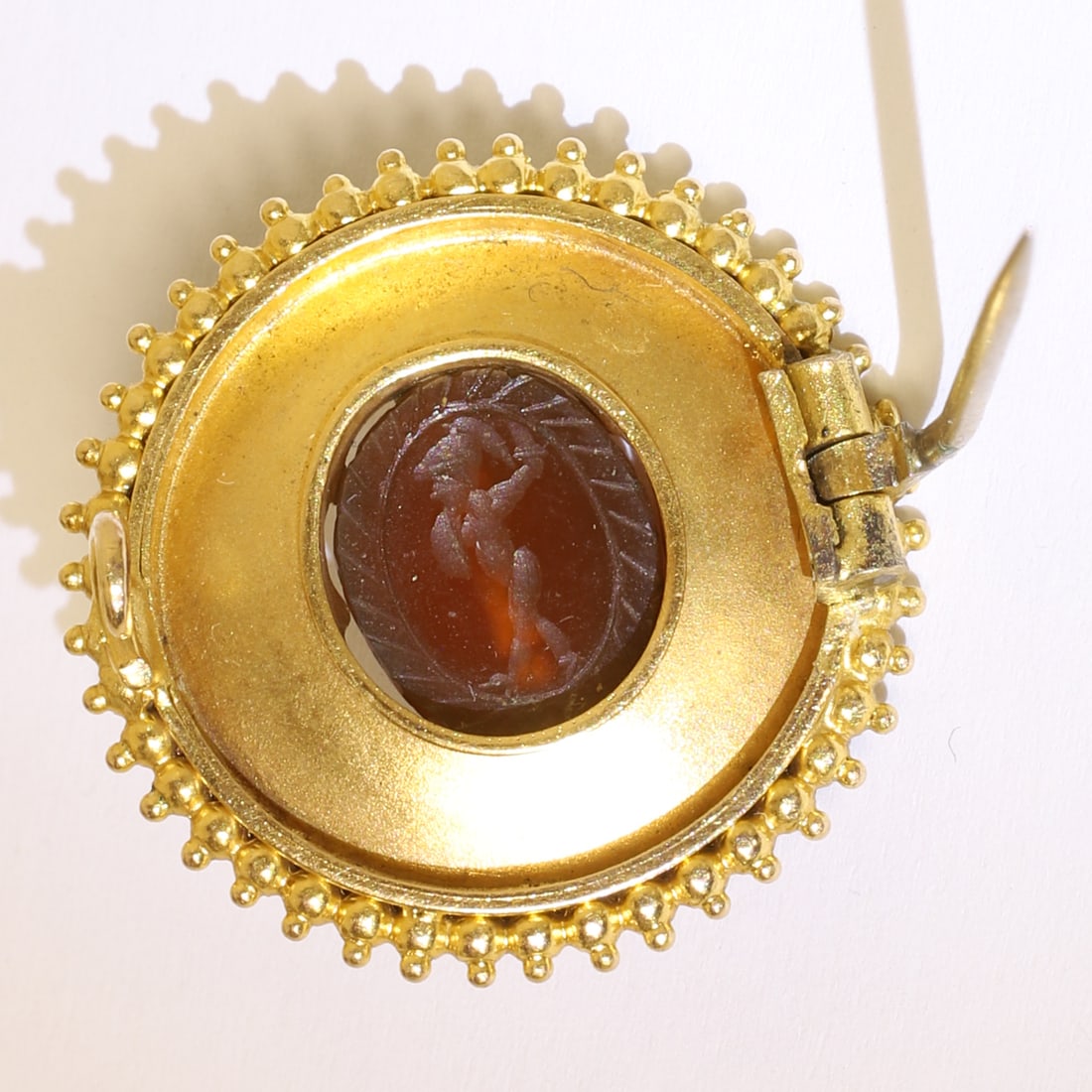 FINE VICTORIAN ETRUSCAN REVIVAL SCARAB BROOCH: FINE VICTORIAN ETRUSCAN REVIVAL SCARAB BROOCH,4,4 grams, testing high carat gold.The centre with a fine cameo carved hardstone of a scarab, with a carved intaglio of a warrior on the back.The surmount