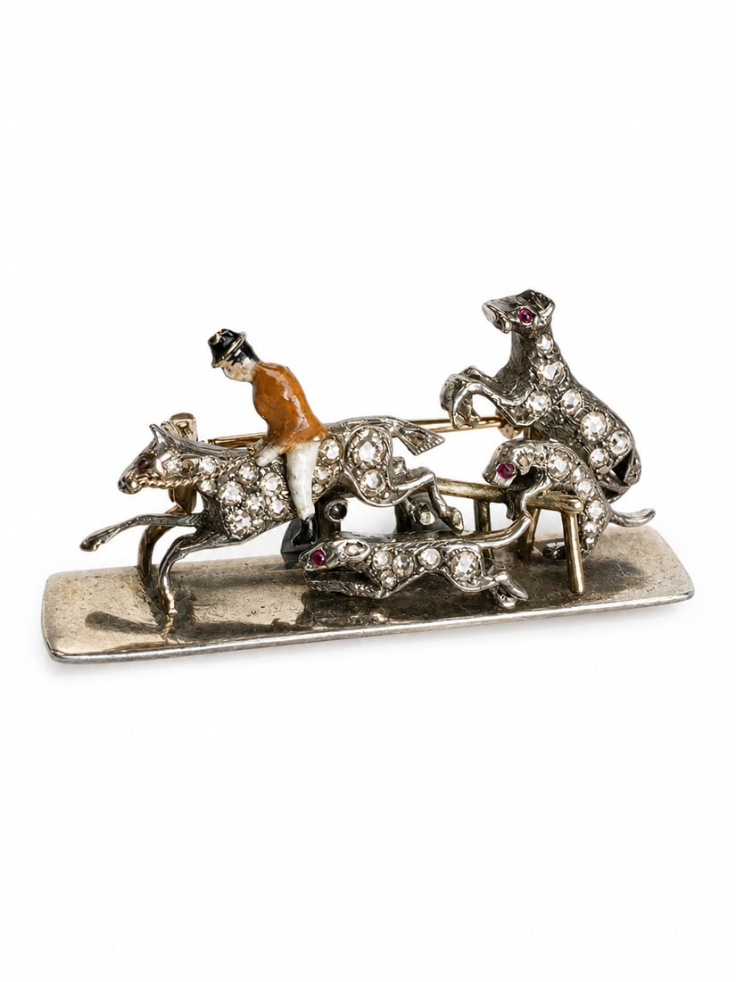 RARE AND UNUSUAL ANTIQUE DIAMOND AND ENAMEL HUNTING SCENE BROOCH: RARE AND UNUSUAL ANTIQUE DIAMOND AND ENAMEL HUNTING SCENE BROOCH,8.5 grams, testing 18 ct. gold and silver.The jockey with multi colour enamel.Bright and lively old cut diamonds.W. 3.8 cm.