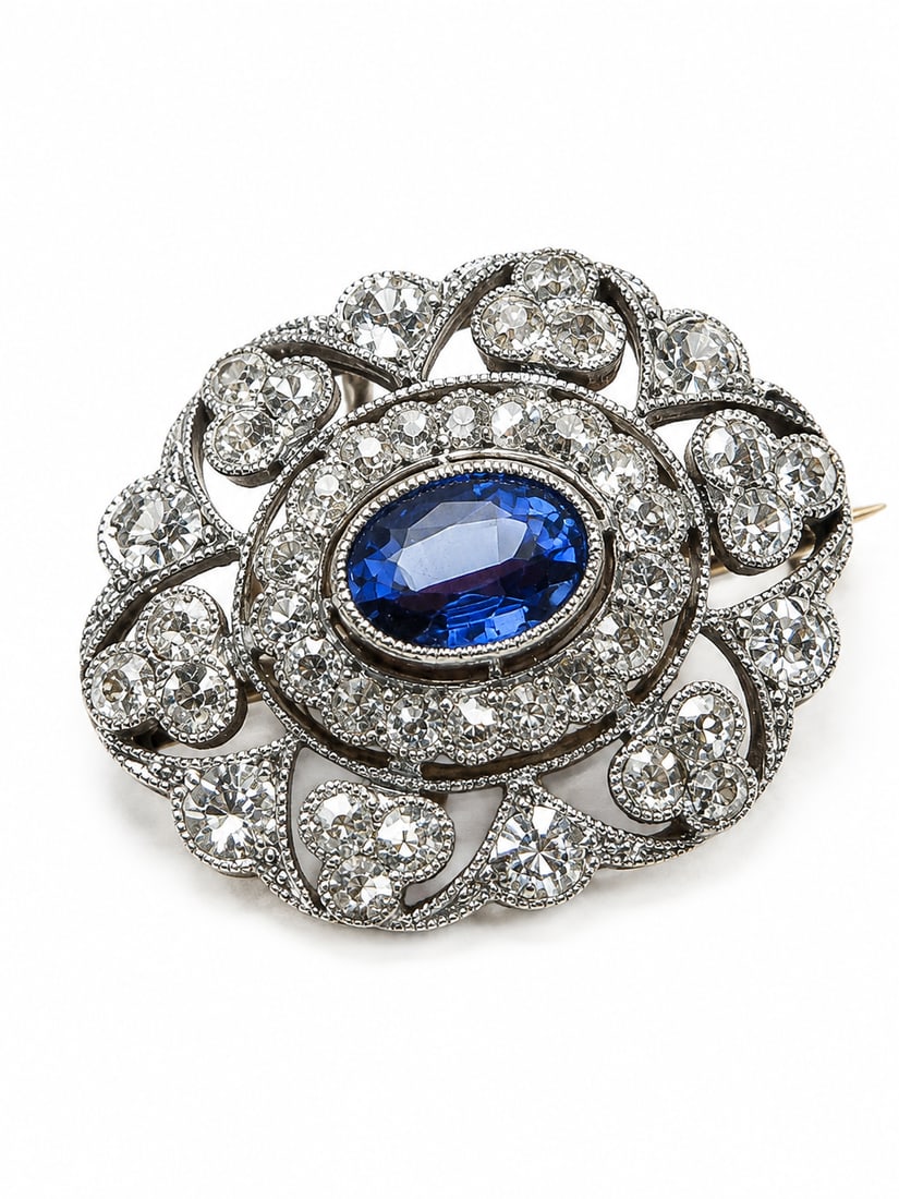 EDWARDIAN SAPPHIRE AND DIAMOND BROOCH: EDWARDIAN SAPPHIRE AND DIAMOND BROOCH,4,9 grams, testing 18 ct. gold and platinum.Bright and lively diamonds, totalling approx. 1.60 ct.Rich and vibrant sapphire of approx. 0.95 ct.W. 2.2 cm.