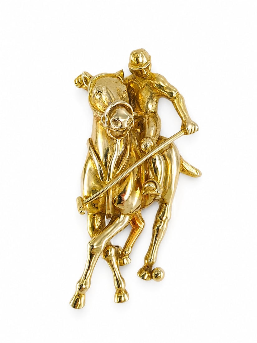 THEO FENNELL, POLO PLAYER AND HORSE BROOCH: THEO FENNELL, POLO PLAYER AND HORSE BROOCH,19.5 grams, 18 ct. gold.Depicting a polo player on a horse.Signed Fennell.L. 4.6 cm.With pouch and box.