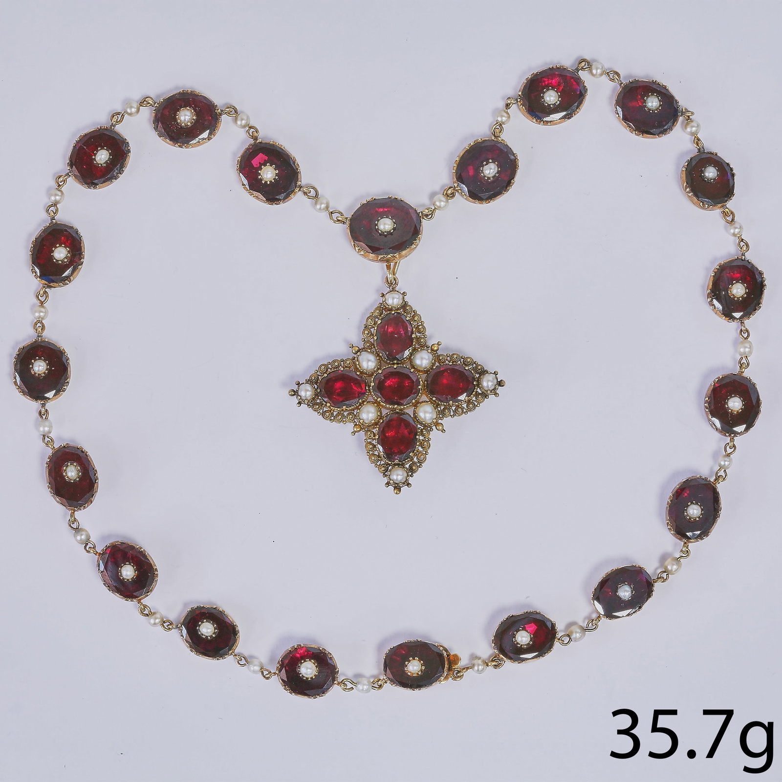 GEORGIAN PEARL AND GARNET NECKLACE WITH PENDANT: GEORGIAN PEARL AND GARNET NECKLACE WITH PENDANT,35,7 grams, testing high carat gold.Each link of the necklace with a fine garnet, set with a pearl to the centre.The pendant cross set with garnets and 