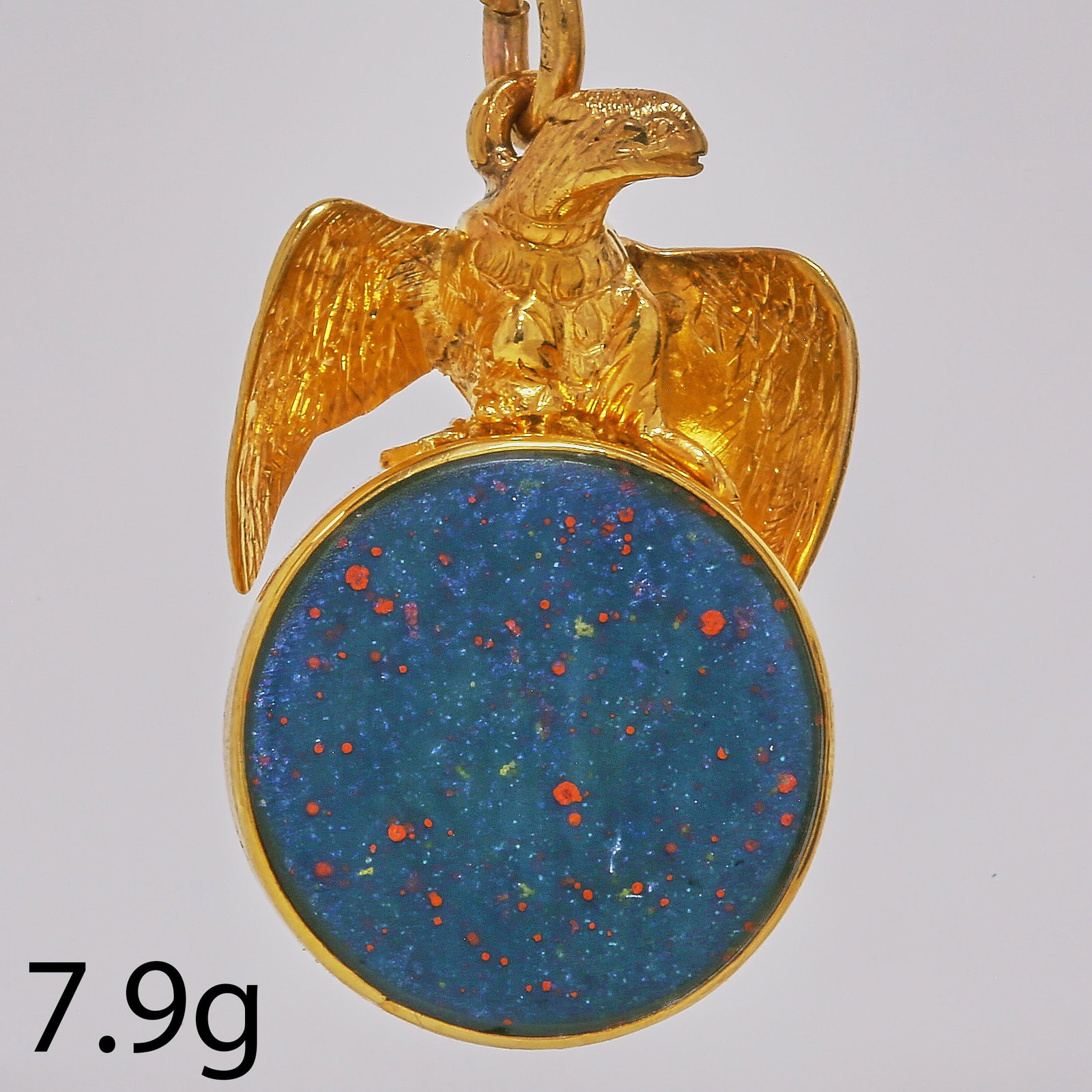 GOLD EAGLE BLOODSTONE FOB SEAL PENDANT: GOLD EAGLE BLOODSTONE FOB SEAL PENDANT,7.9 grams.The 3 dimensional shaped eagle holding a tilting bloodstone in his claws.L. 3.2 cm.