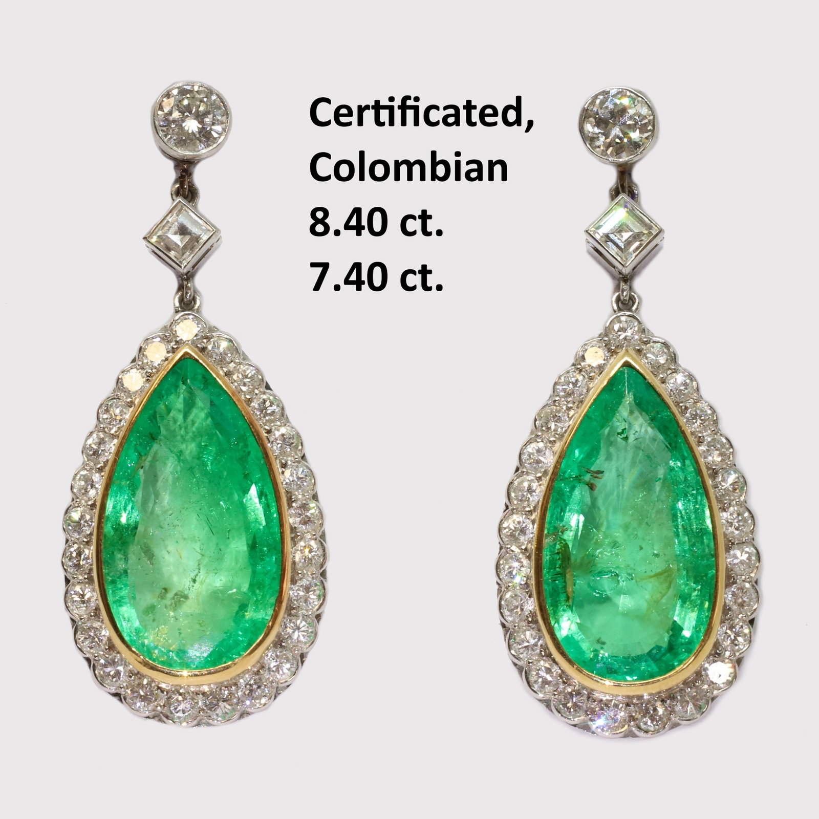 FANTASTIC PAIR OF 8.40 AND 7.40 CT. CERTIFICATED COLOMBIAN EMERALD AND DIAMOND EARRINGS,: FANTASTIC PAIR OF 8.40 AND 7.40 CT. CERTIFICATED COLOMBIAN EMERALD AND DIAMOND EARRINGS,15,6 grams, testing platinum.The emeralds of a 8.40 ct. and a 7.40 ct. (Certificated, Colombian, moderate.).Surr