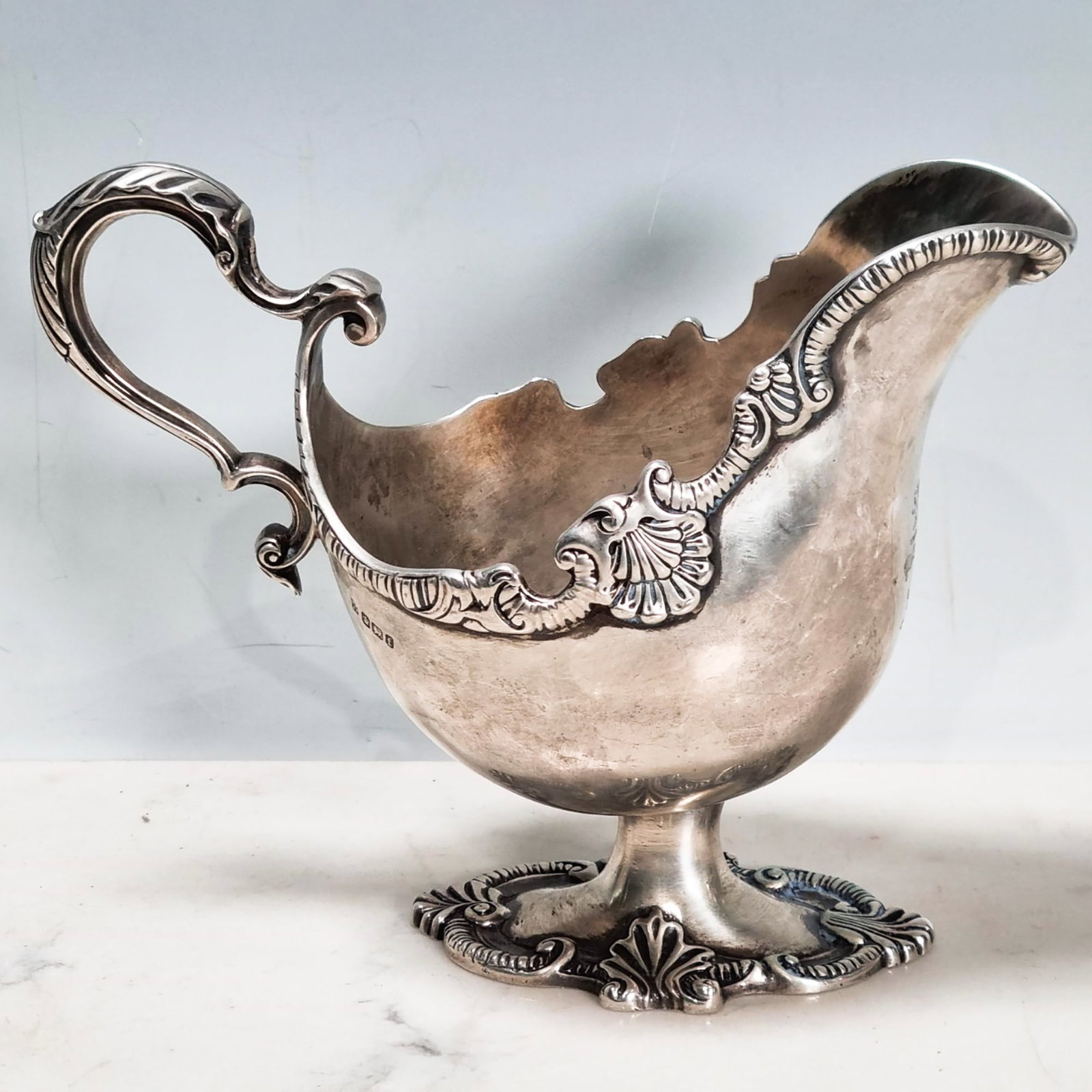 VICTORIAN SILVER SAUCE BOAT WITH SCALLOPED RIM,: VICTORIAN SILVER SAUCE BOAT WITH SCALLOPED RIM,460 grams.Relief scalloped rim and foot.With family crest.Sheffield, 1898.