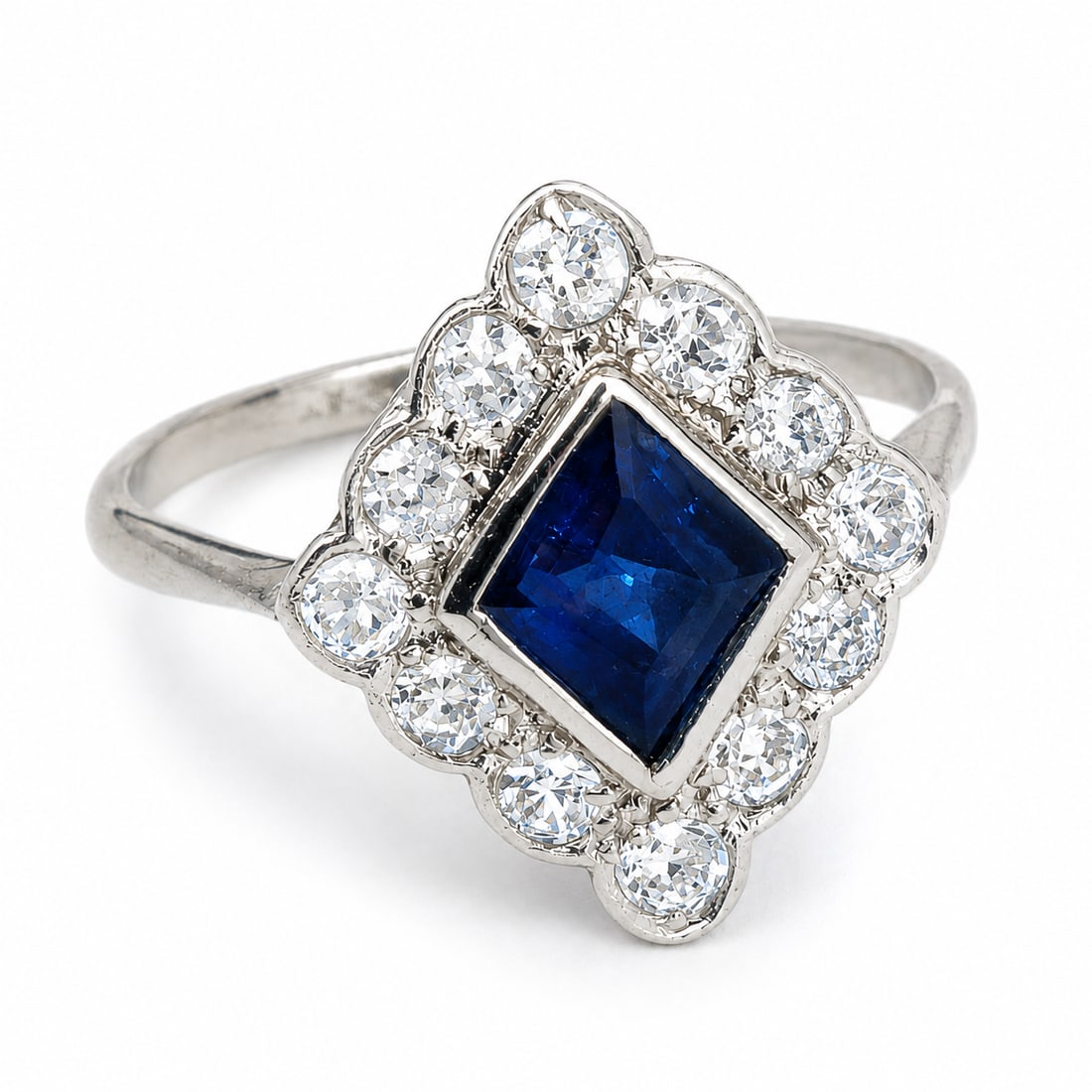 SAPPHIRE AND DIAMOND CLUSTER RING: SAPPHIRE AND DIAMOND CLUSTER RING,18 ct. gold.Rich and vibrant sapphire.Diamonds bright and lively.Size Q 1/2.