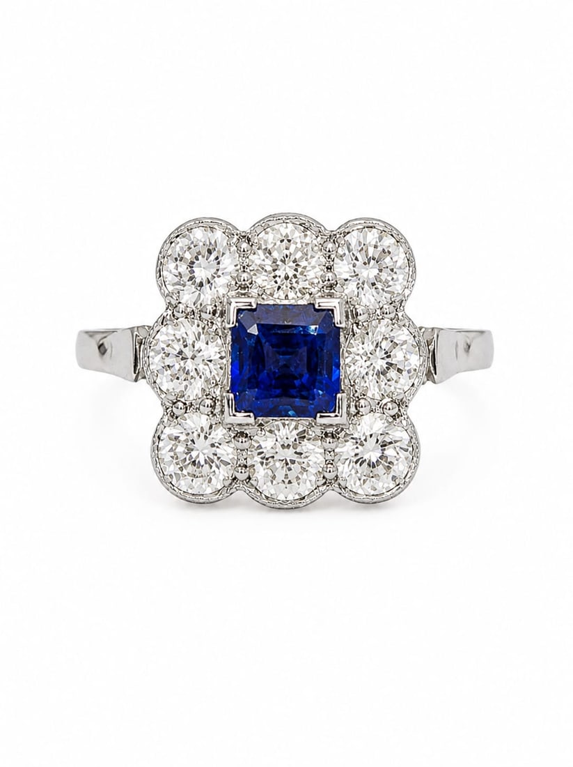 SAPPHIRE AND DIAMOND CLUSTER RING: SAPPHIRE AND DIAMOND CLUSTER RING,4,6 grams, 18 ct. gold and platinum.Vibrant sapphire of approx. 0.80 ct.Diamonds bright and lively totalling approx. 1.80 ct.Size N 1/2.