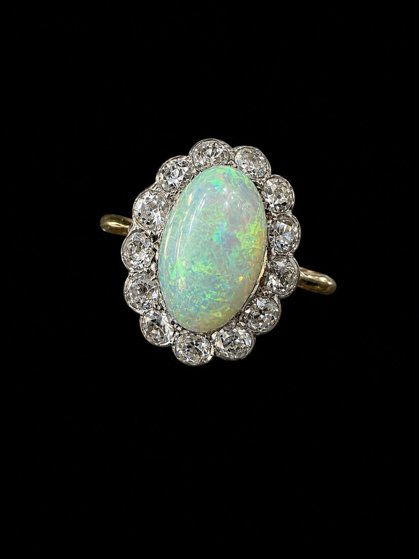 OPAL AND DIAMOND CLUSTER RING: OPAL AND DIAMOND CLUSTER RING,3,1 grams, testing high carat gold.Lovely opal with good play of colour of approx. 11,74 mm.Bright and lively old cut diamonds.Size Q 1/2.
