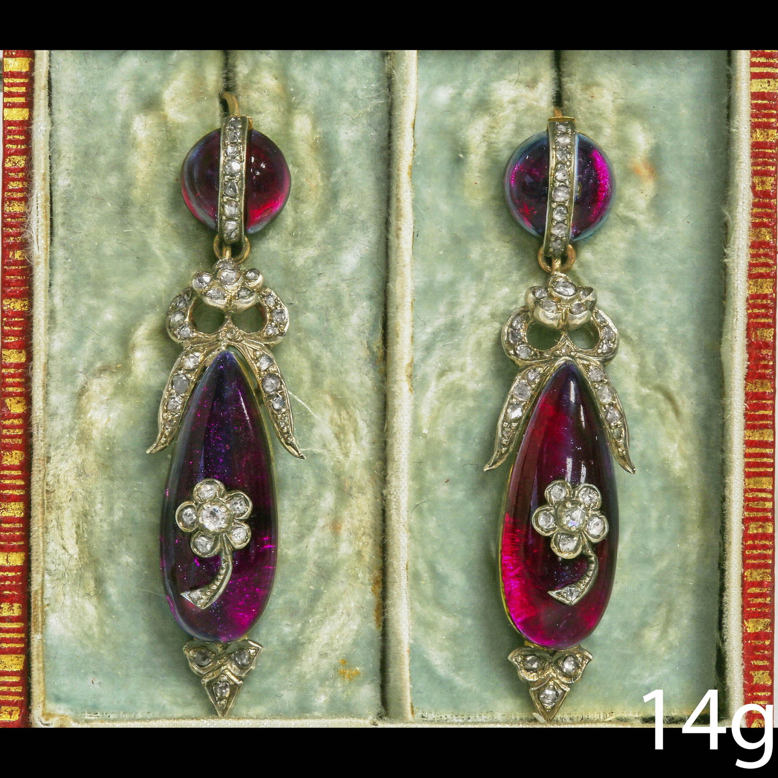 VERY FINE PAIR OF ANTIQUE DIAMOND AND GARNET DROP EARRINGS: VERY FINE PAIR OF ANTIQUE DIAMOND AND GARNET DROP EARRINGS,14 grams.Fine cabochon cut garnets. The larger drops set with a floral diamond applique, hanging from and diamond set styllized bow.The tops 